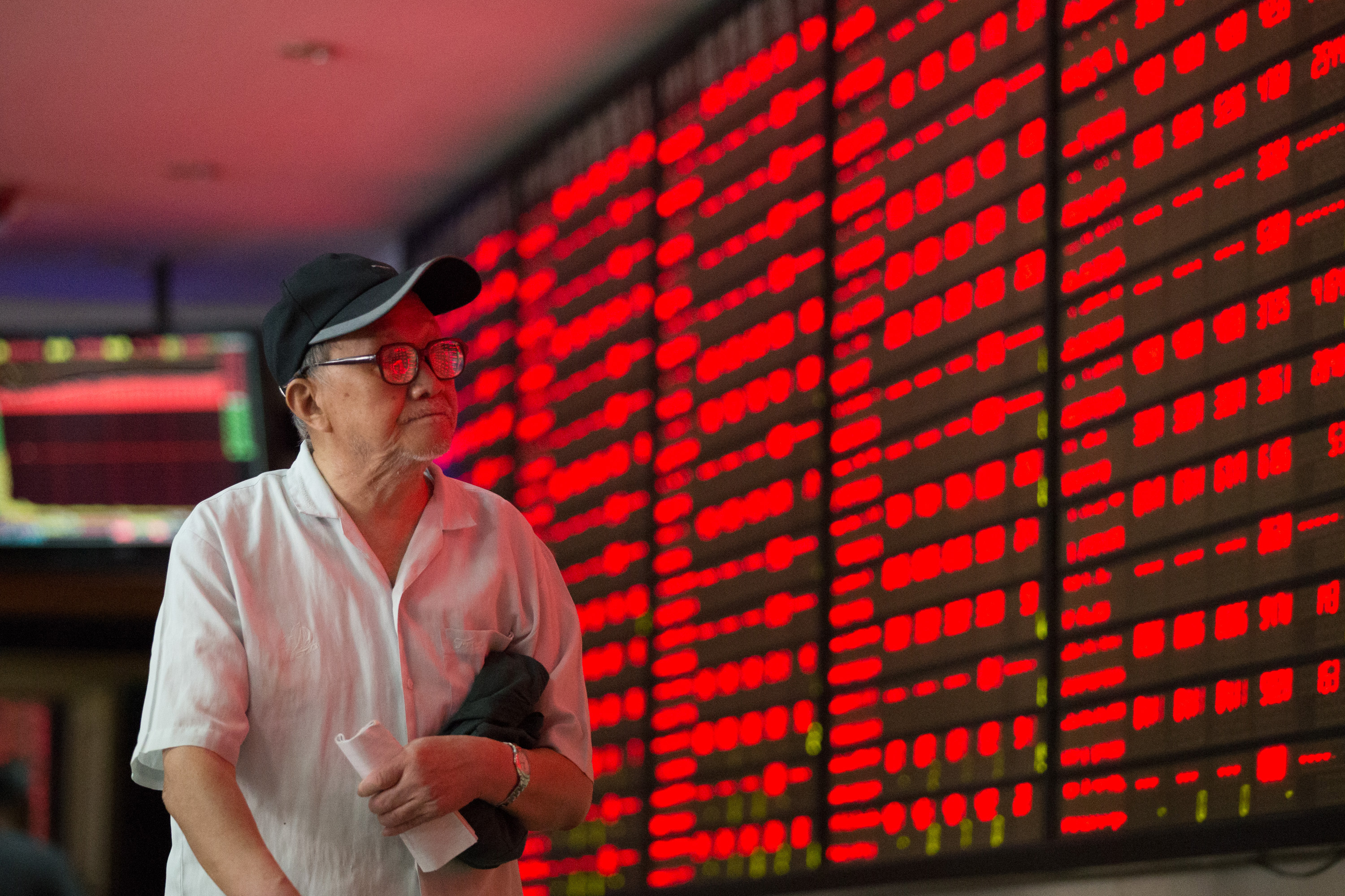 An elderly investor watches stock prices in China as markets in Hong Kong and Shanghai were weaker on Tuesday. Photo: Xinhua 