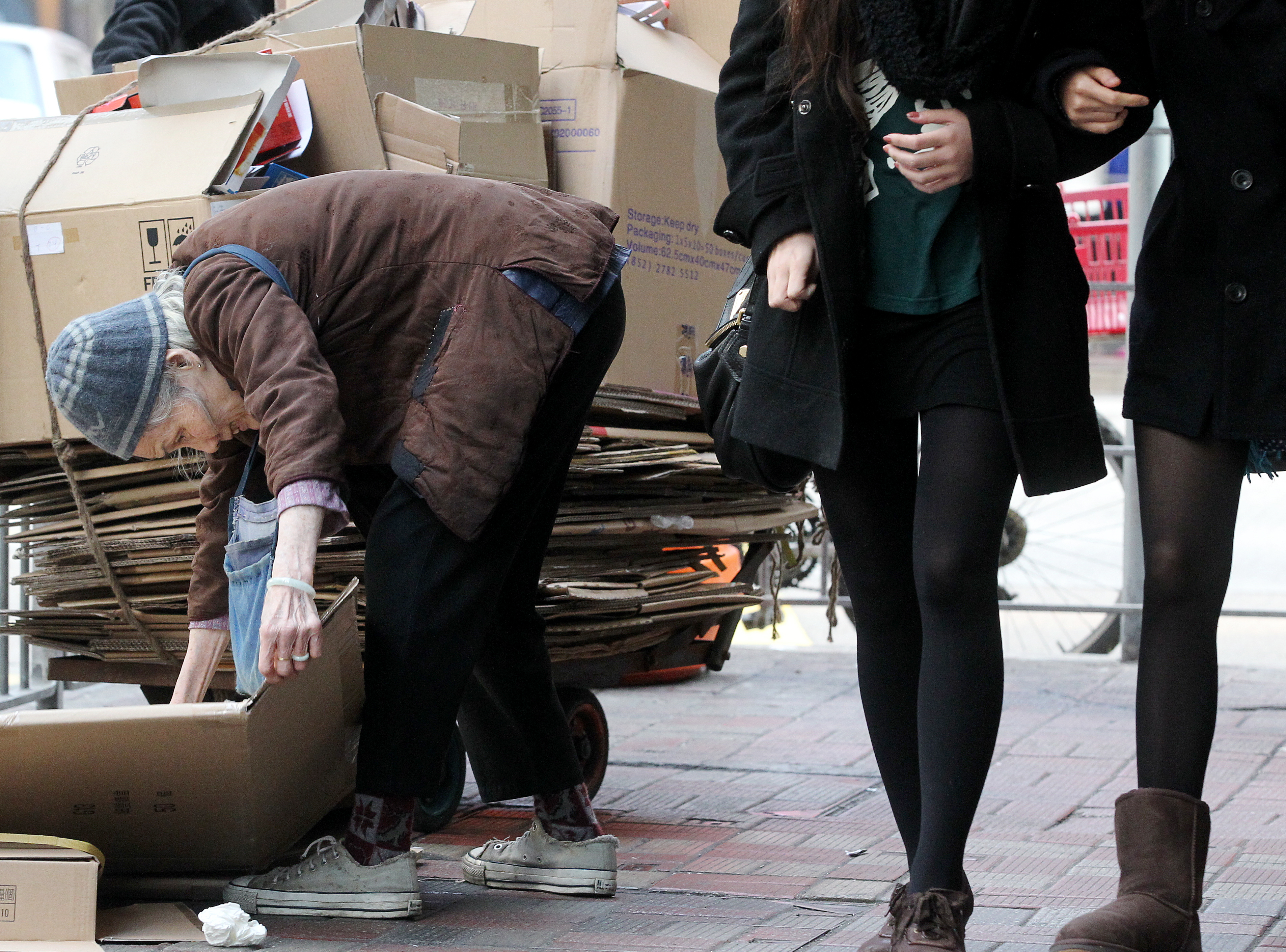 An old woman collects cardboard for cash in Causeway Bay. Photo: K. Y. Cheng
