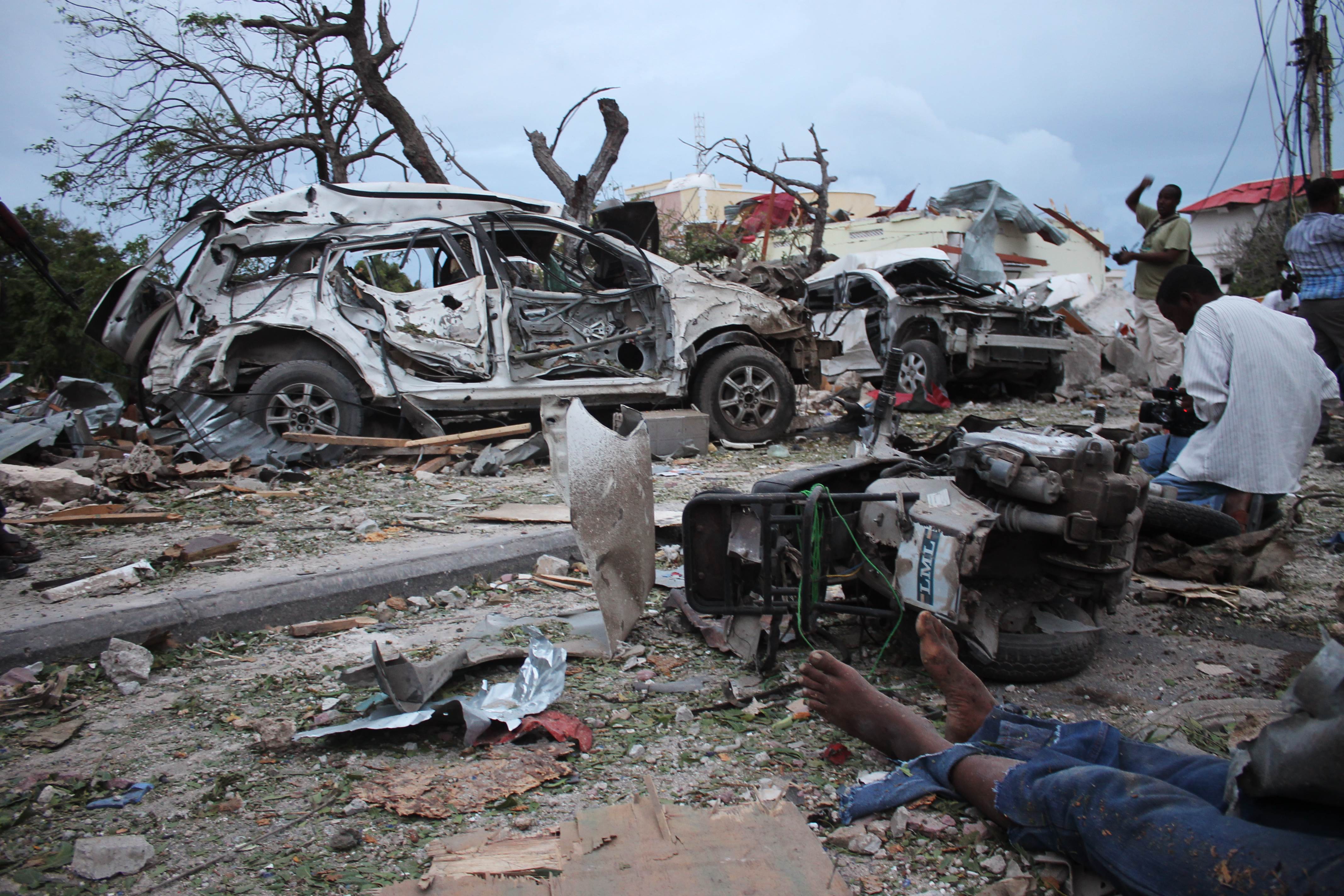 A body lies in the rubble next to damaged cars near the Jazeera Palace hotel following a suicide attack in Mogadishu. Photo: AFP