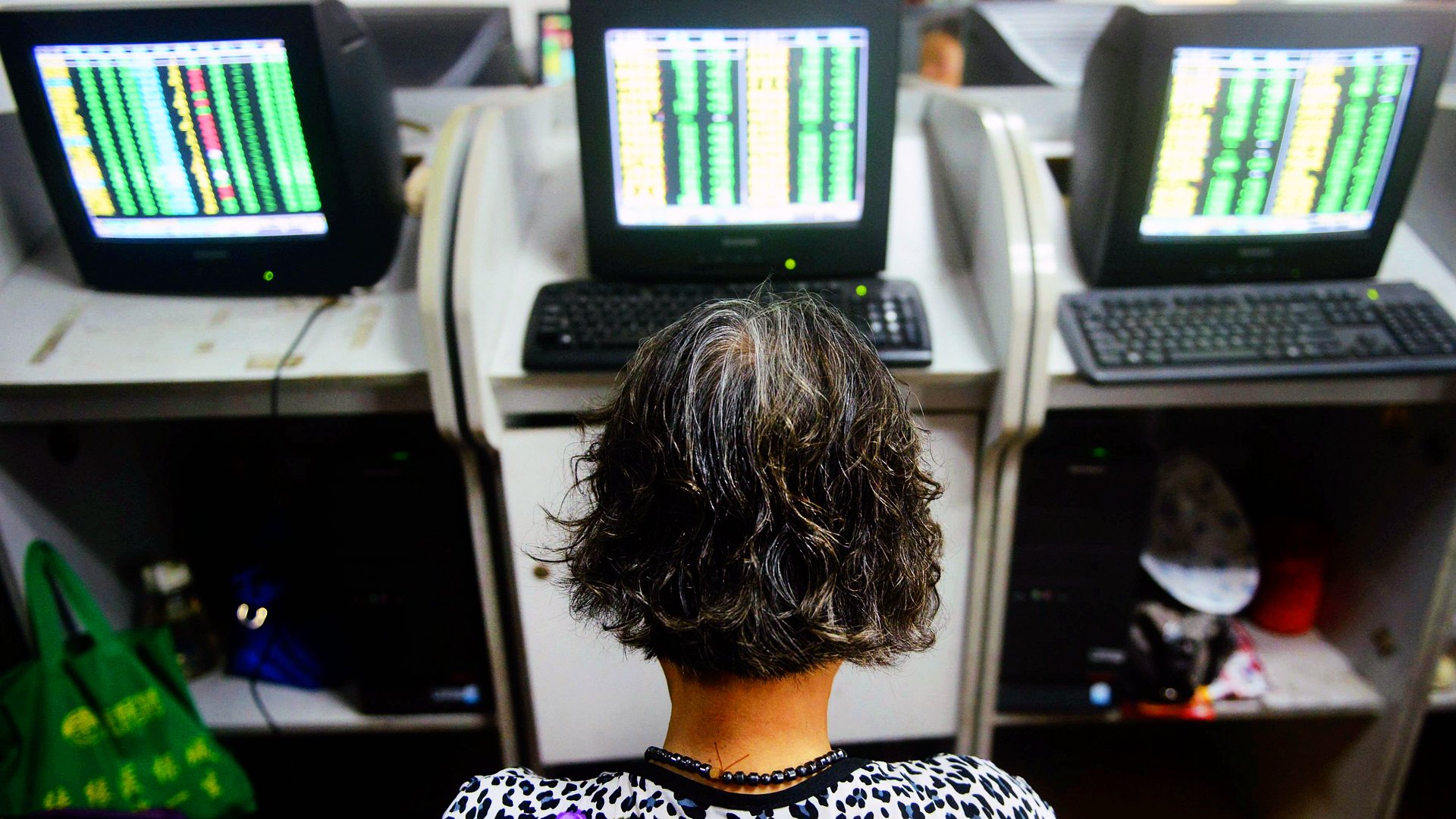 A woman investor in China eyes a bank of electronic monitors showing stock prices as stocks in Shanghai recovered from an early beating on Tuesday. Photo: Xinhua