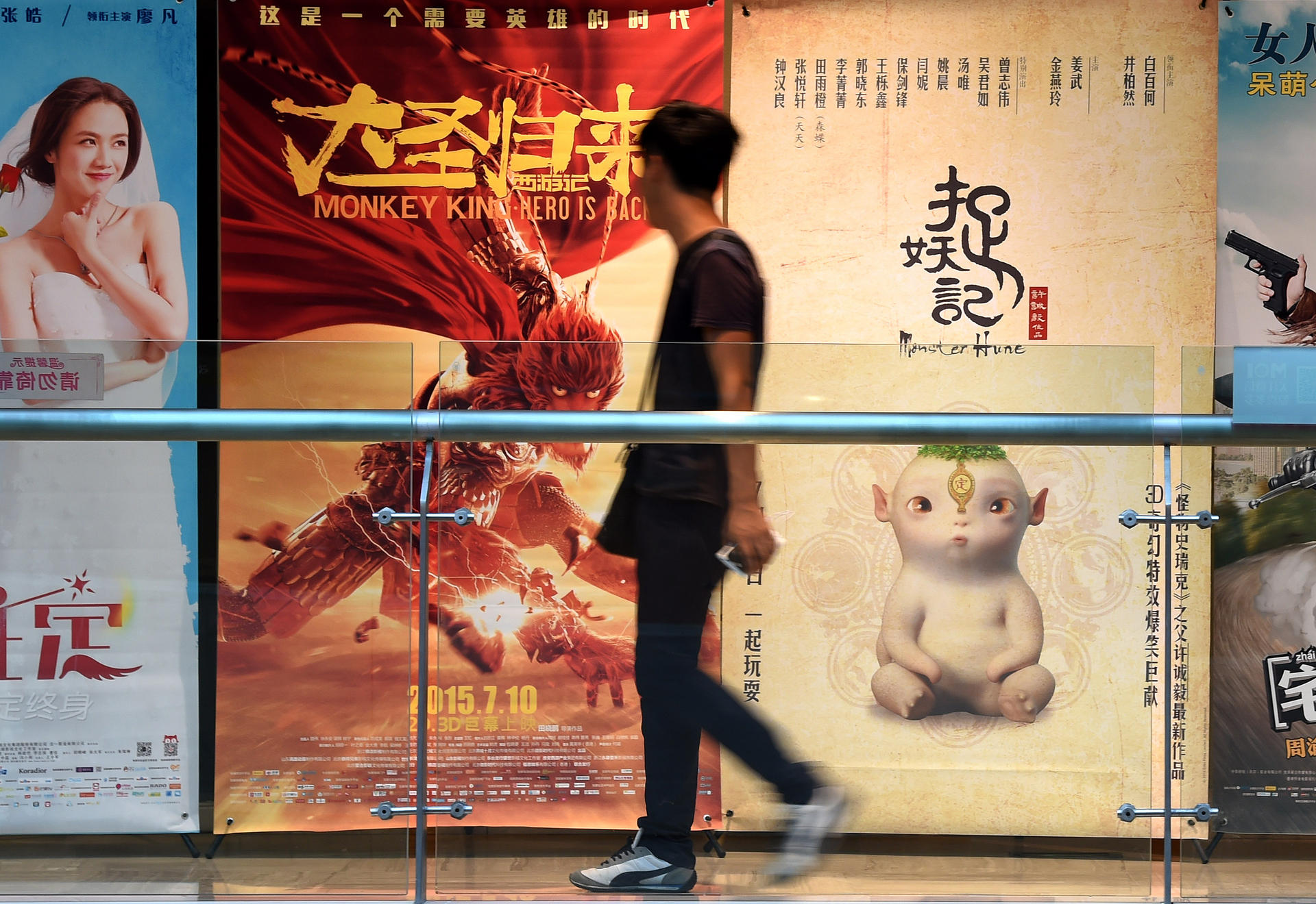 A man walks past a poster for Monster Hunt outside a cinema in Shenyang in the northeast of China. The film has become the biggest hit in Chinese cinema's history. Photo: Li Gang