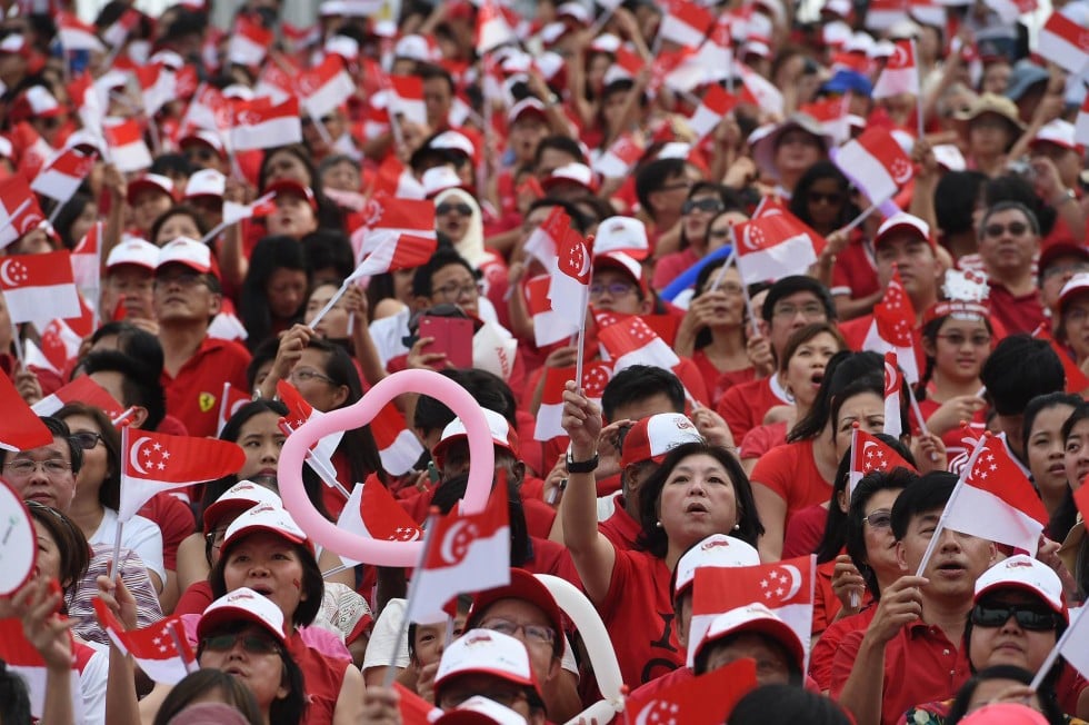 Thousands wave national flags during August 9 festivities. Photo: AFP