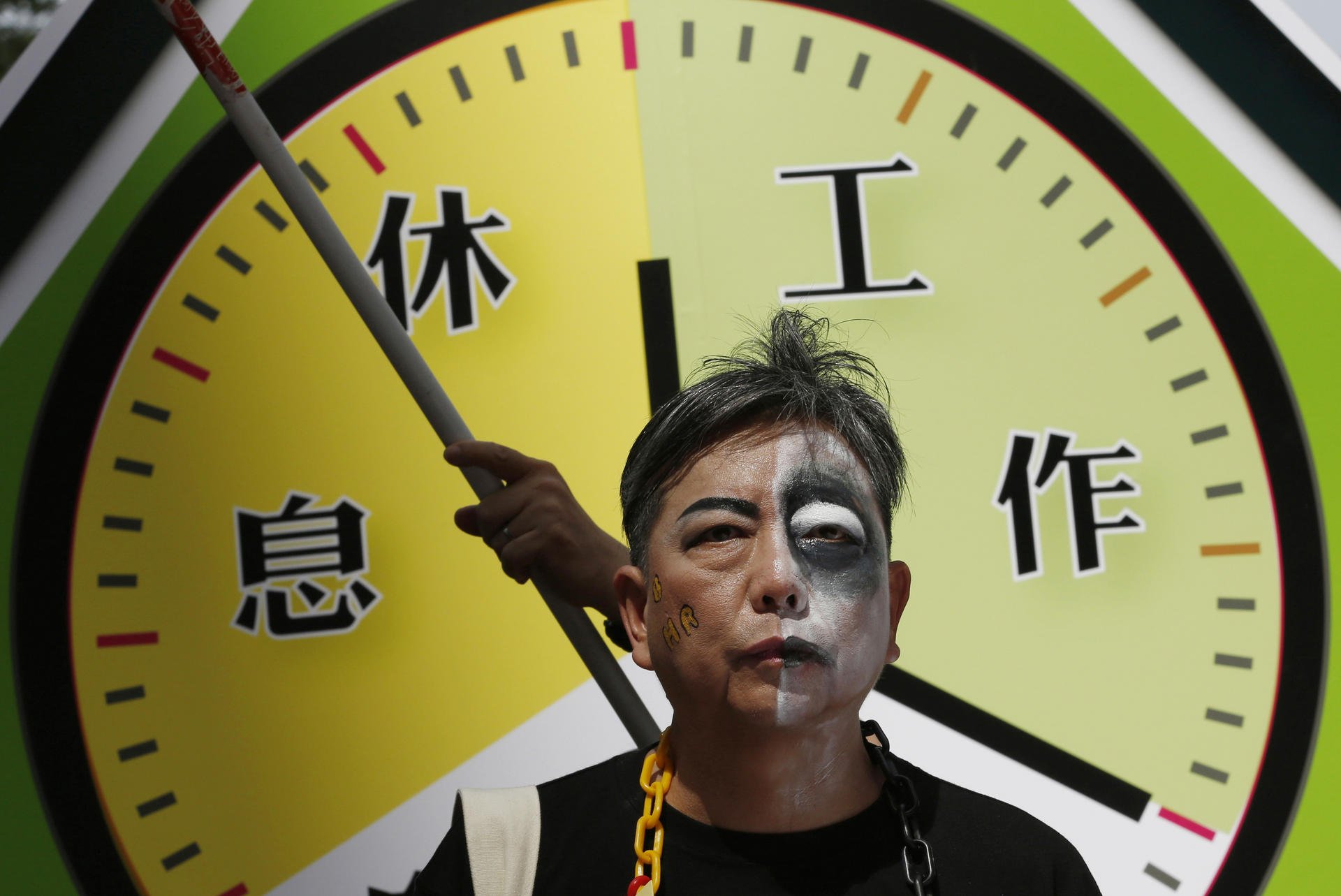 A protester at a rally for workers' rights seeks to ensure standard working hours in HK.Photo: AP