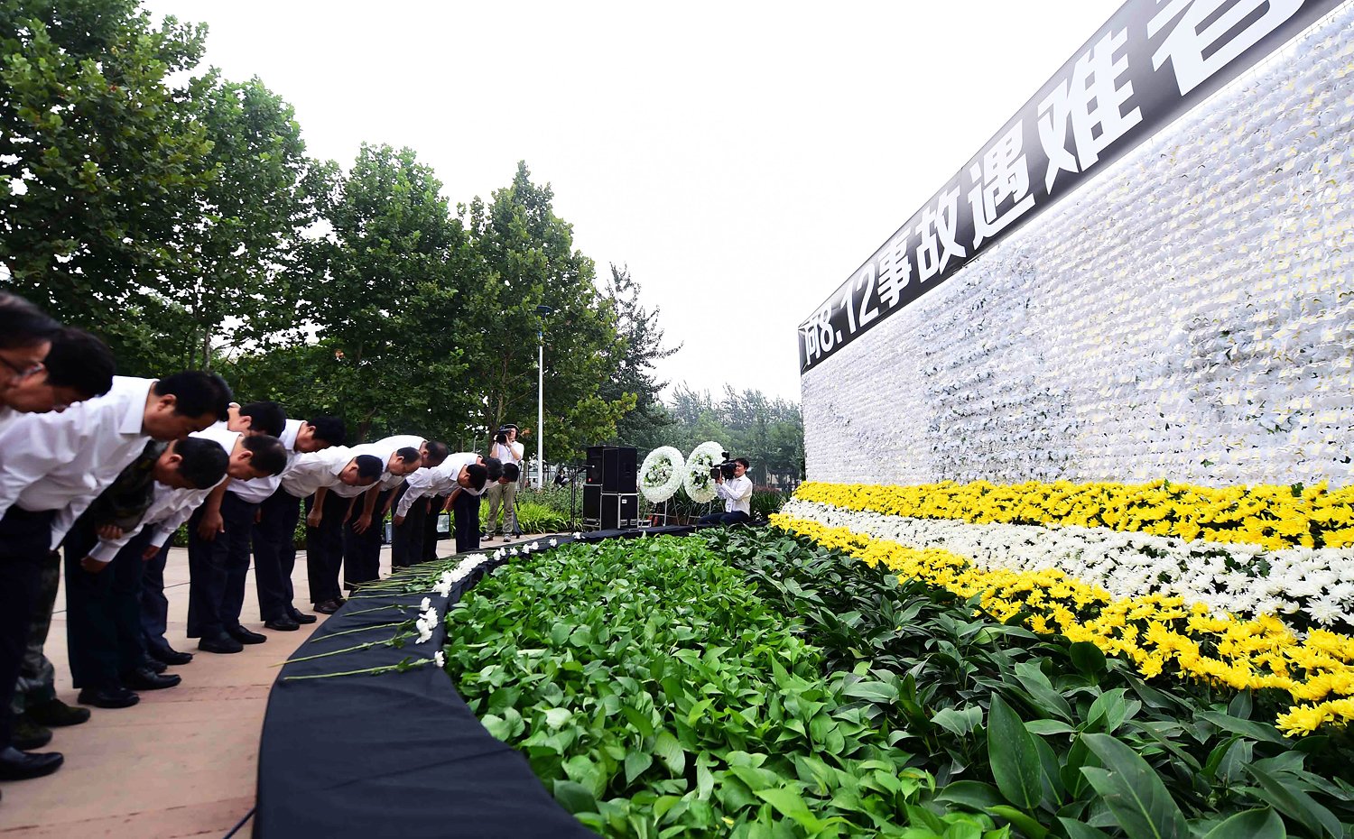 Mourners pay respects at a ceremony in a Binhai New Area park. Photo: Xinhua