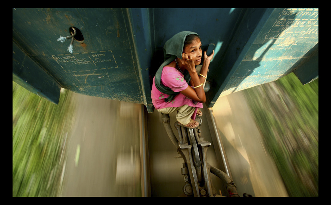 A woman hitches a ride between two train carriages in Bangladesh, by G.M.B. Akash, overall winner of the 2009 Travel Photographer of the Year award.
