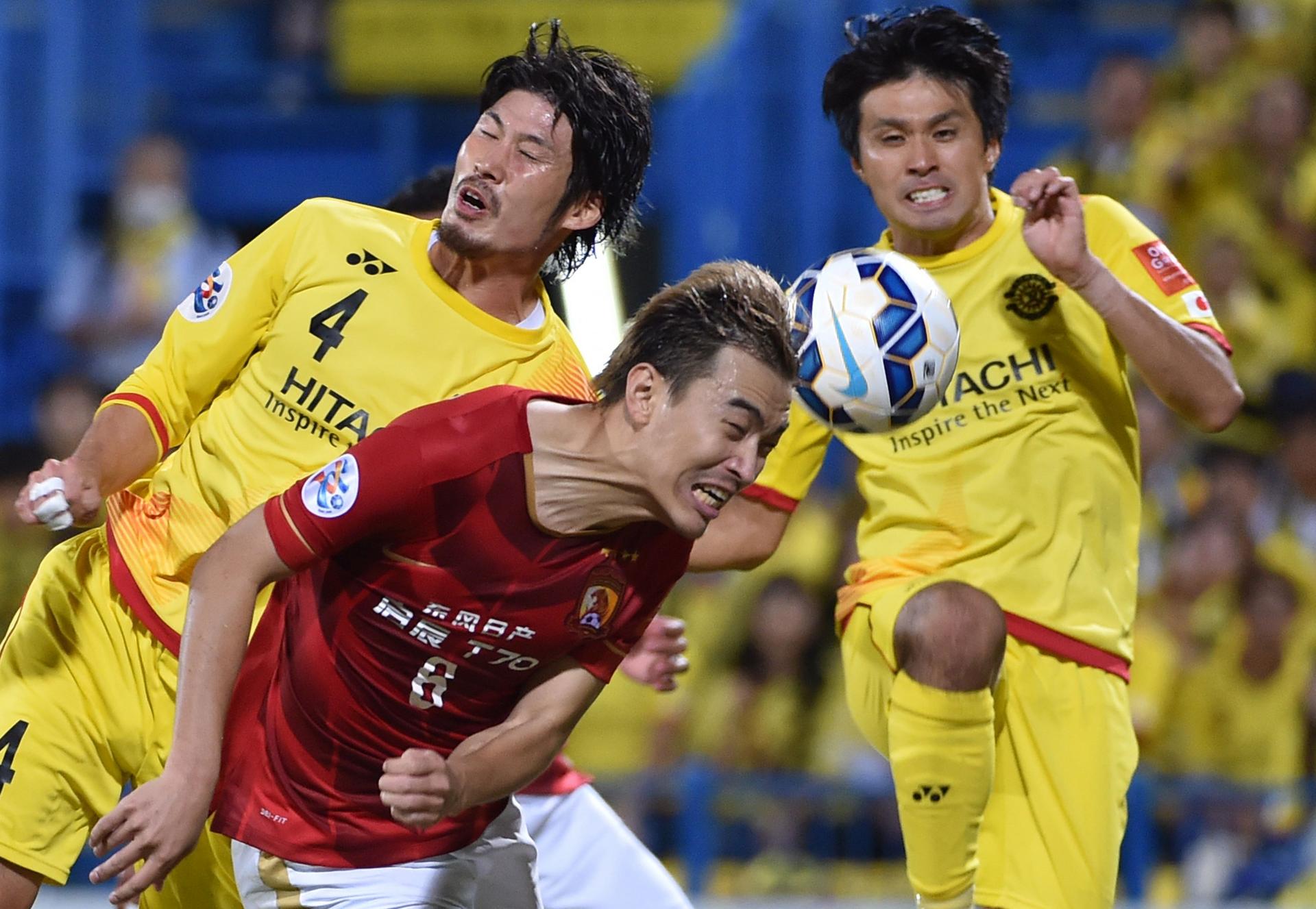 Guangzhou Evergrande defender Feng Xiaoting finds himself sandwiched by Kashiwa Reysol defender Daisuke Suzuki and forward Masato Kudo during their AFC Champions League quarter-final clash in Kashiwa. Photo: AFP 