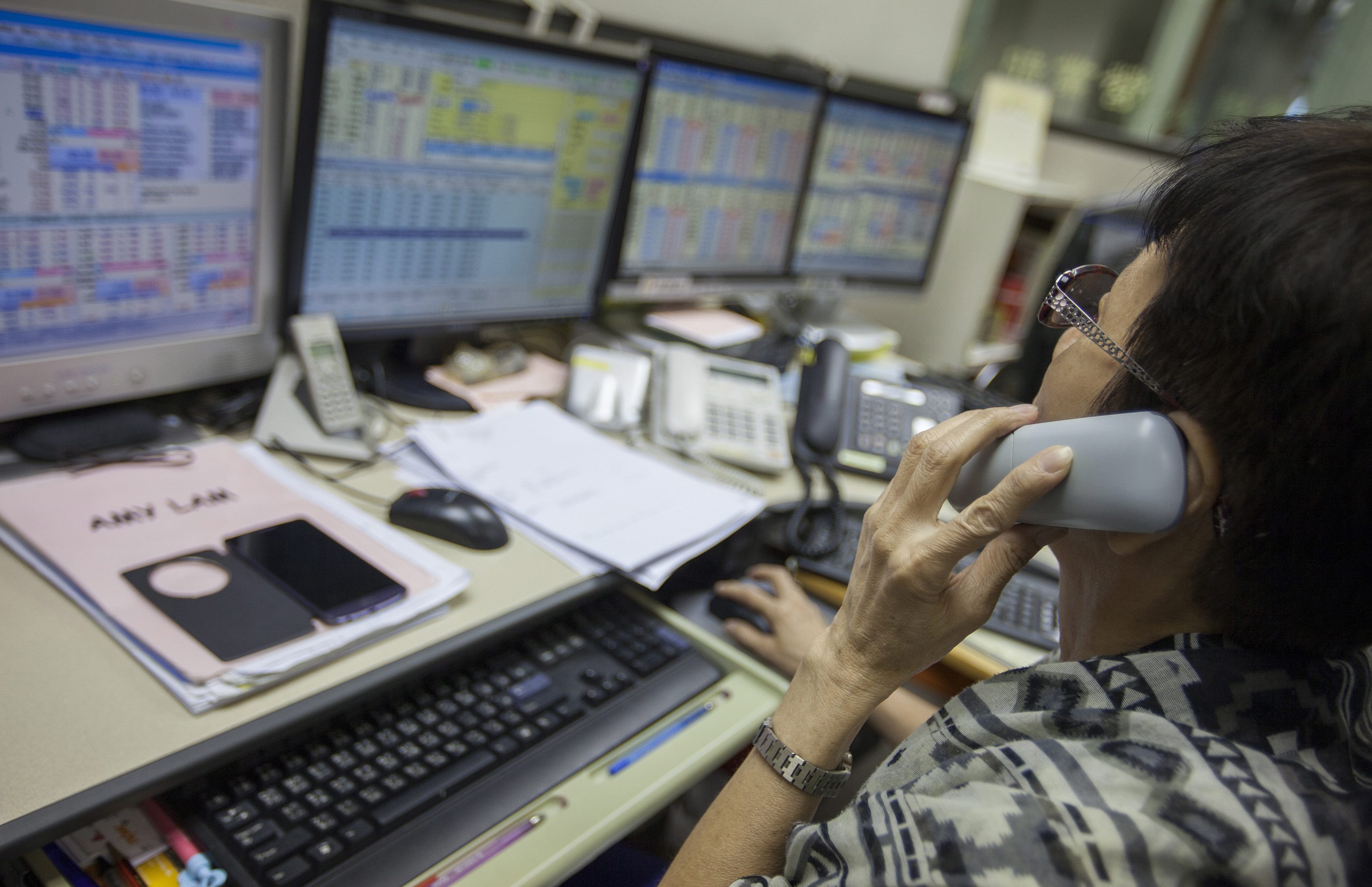 A stock broker works the phones in Hong Kong as the market recovers after getting pounded earlier in the week, with the Hang Seng Index climbing after Wall Street rallied overnight. Photo: EPA 