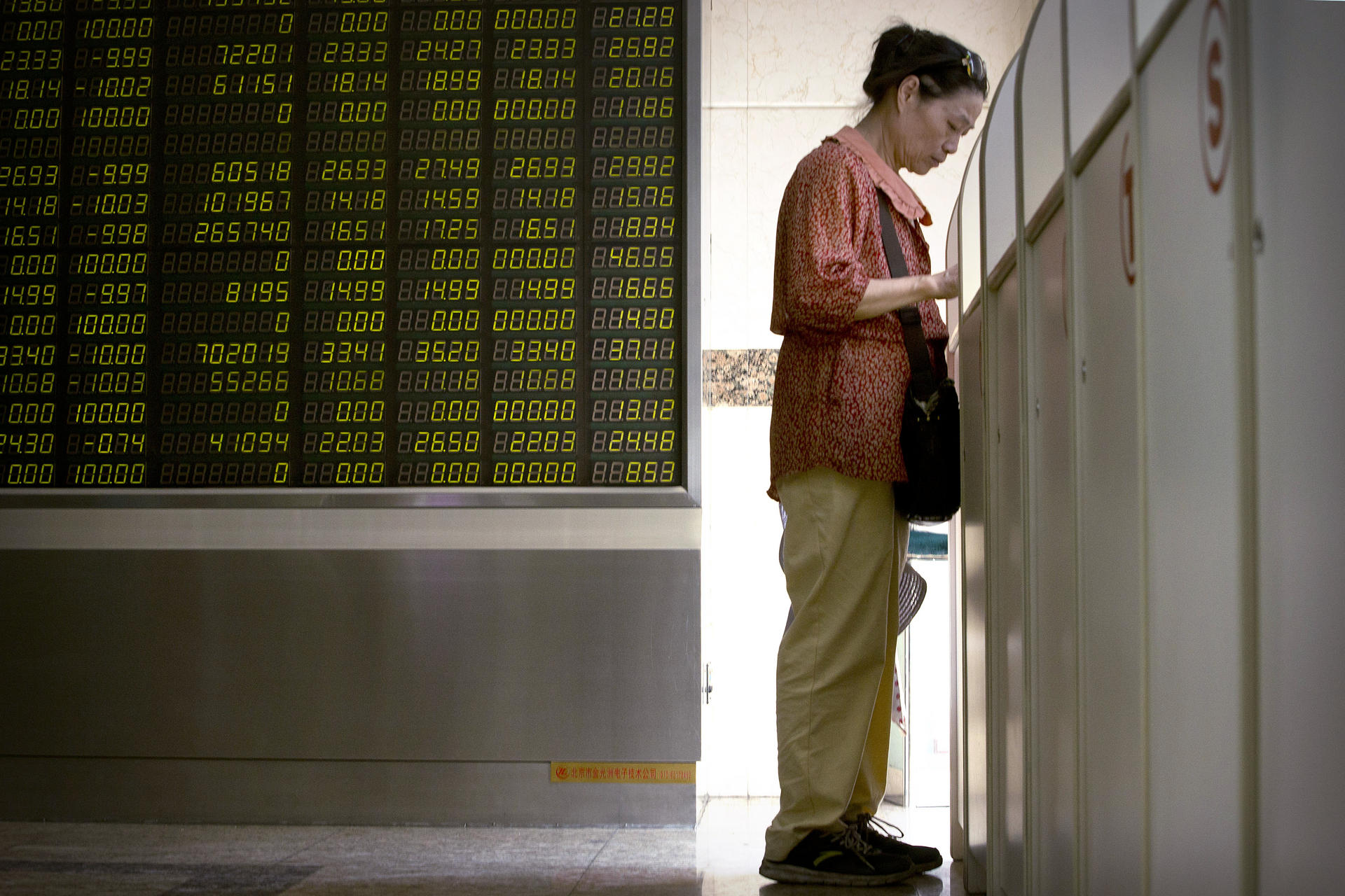 An investor monitors stock prices at a brokerage house in Beijing. Photo: AP