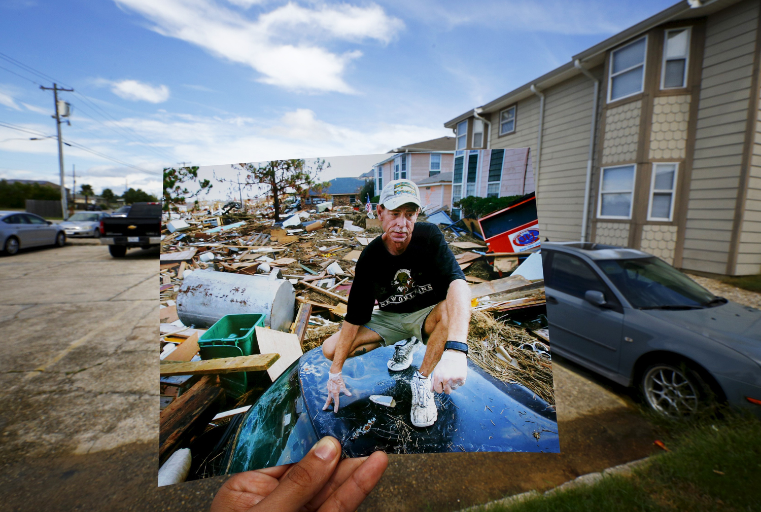 Resident Michael Rehage squats on the roof of his car on September 12, 2005, after Hurricane Katrina struck.