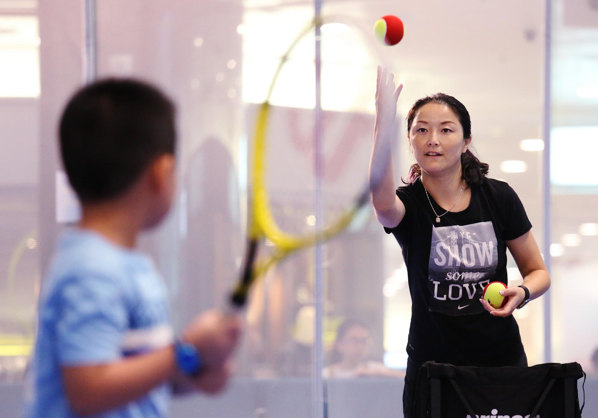 Retired Chinese player Yan Zi instructs a young player during a promotional event. Photo: Nora Tam 