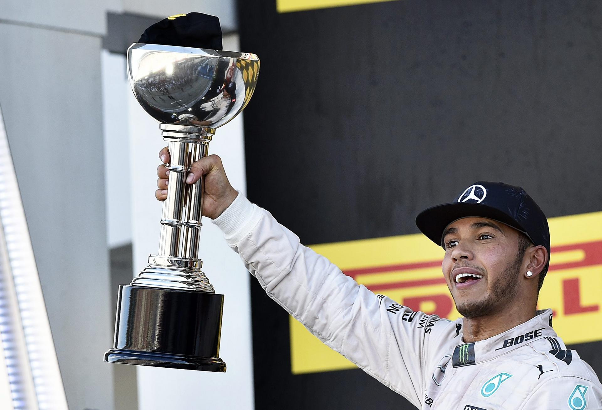 British F1 driver Lewis Hamilton celebrates on the podium after winning the Japanese Formula One Grand Prix at the Suzuka Circuit. Photo: EPA