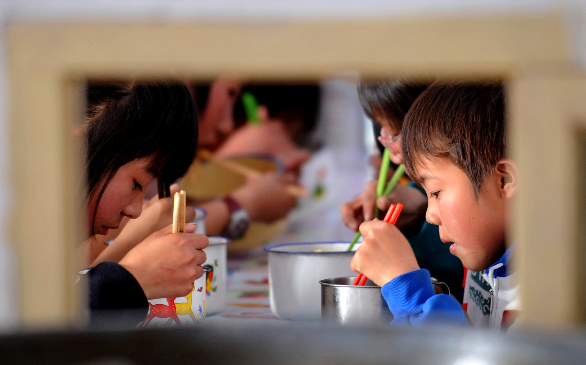 Rural children eat during a lunch break at their boarding school in Lanzhou, Gansu. Study after study shows that financial and in-kind aid reduces poverty. Photo: Xinhua 