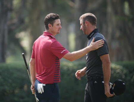 Justin Rose pats Dustin Johnson on the shoulder after they finished their round on Friday. Photo: AP