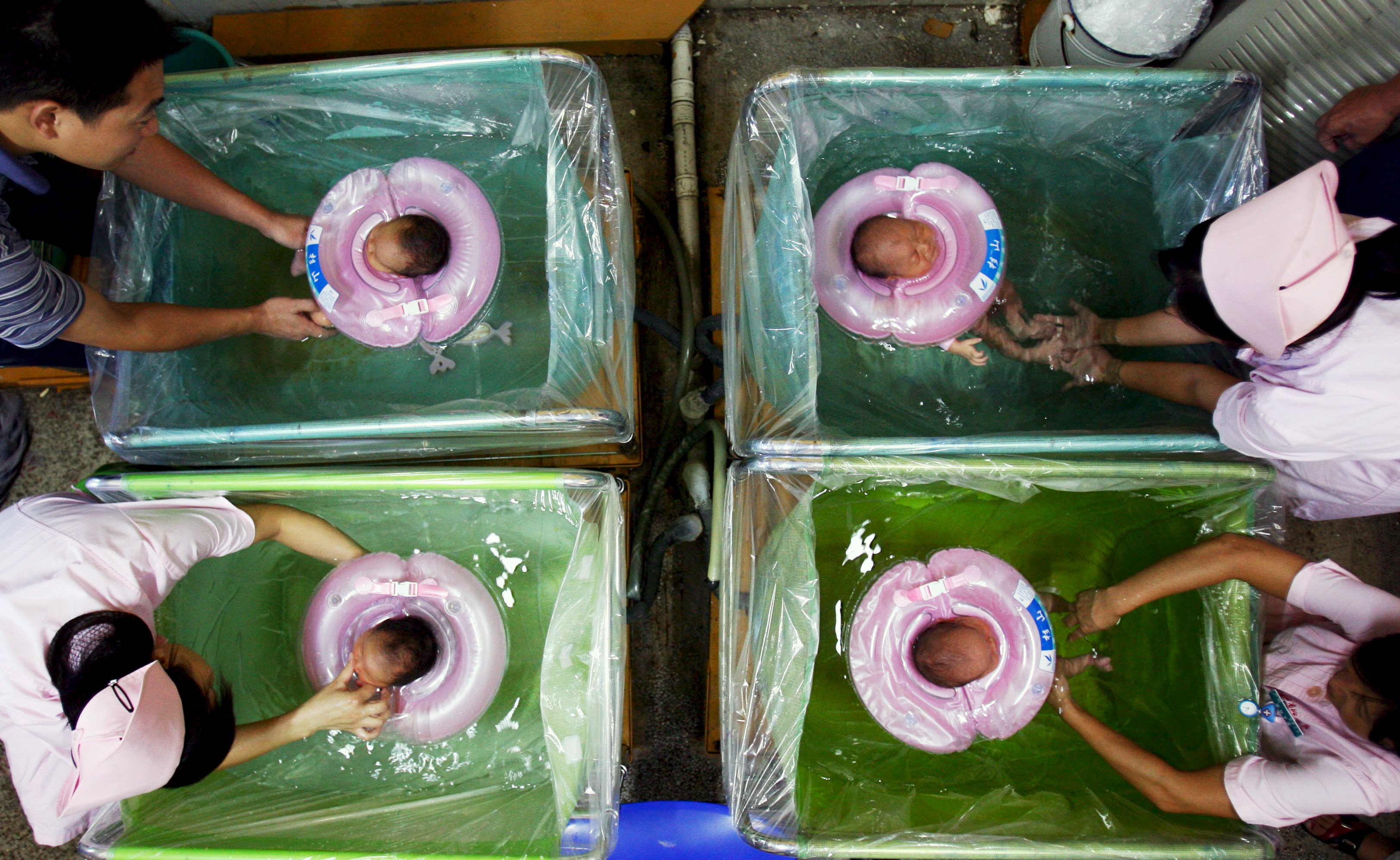 Parents and nurses give newborn babies their baths in a hospital in Wuhan, Hubei province. Photo: Reuters