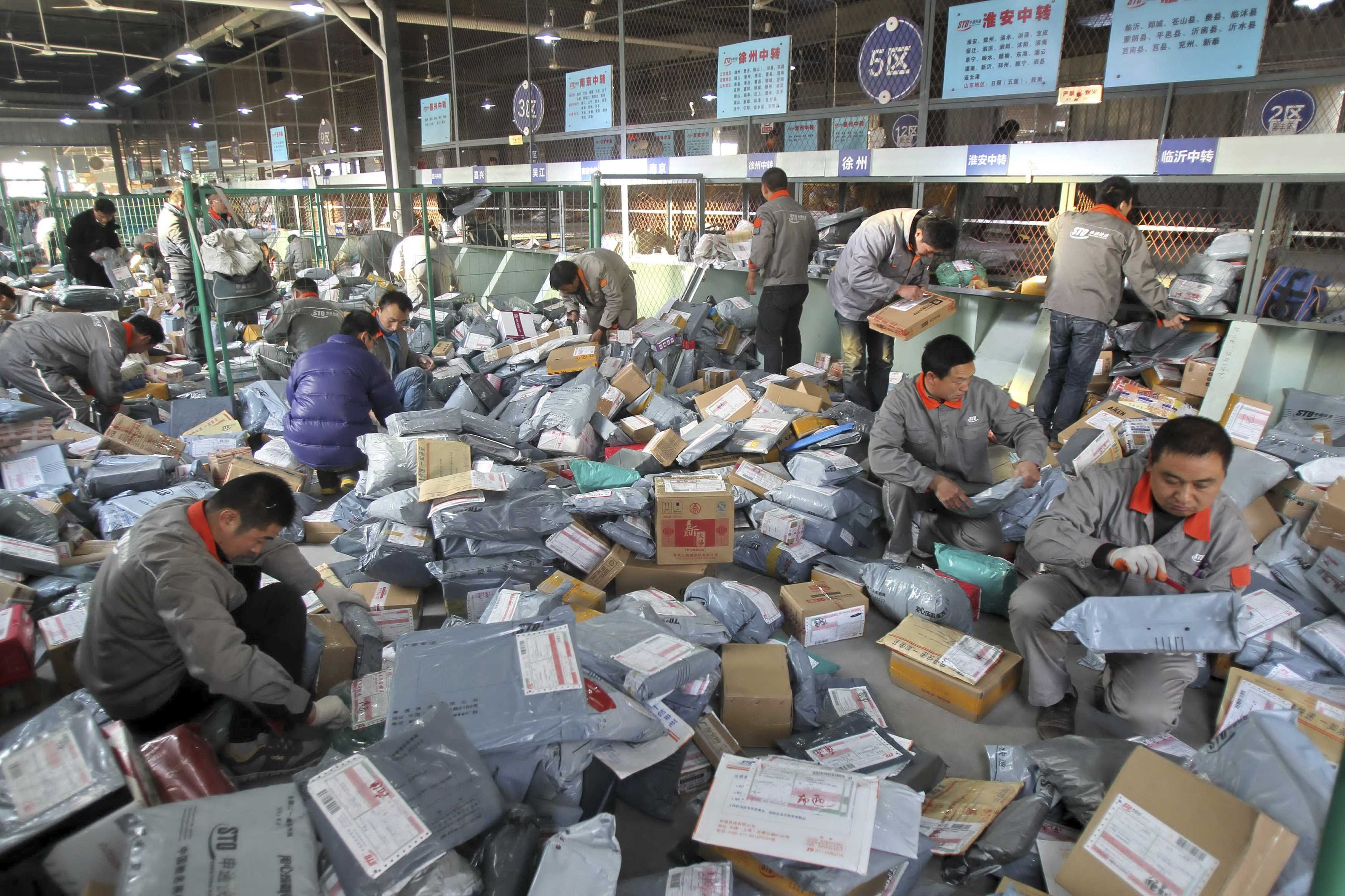 Workers sort out packages at an express delivery company in China's Jiangsu province. Photo: Reuters