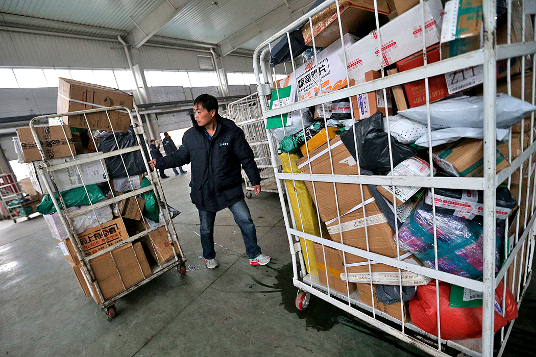 Worker transports parcels at a sorting center of an express delivery company, one day ahead online shopping festival in Beijing. Photo: EPA