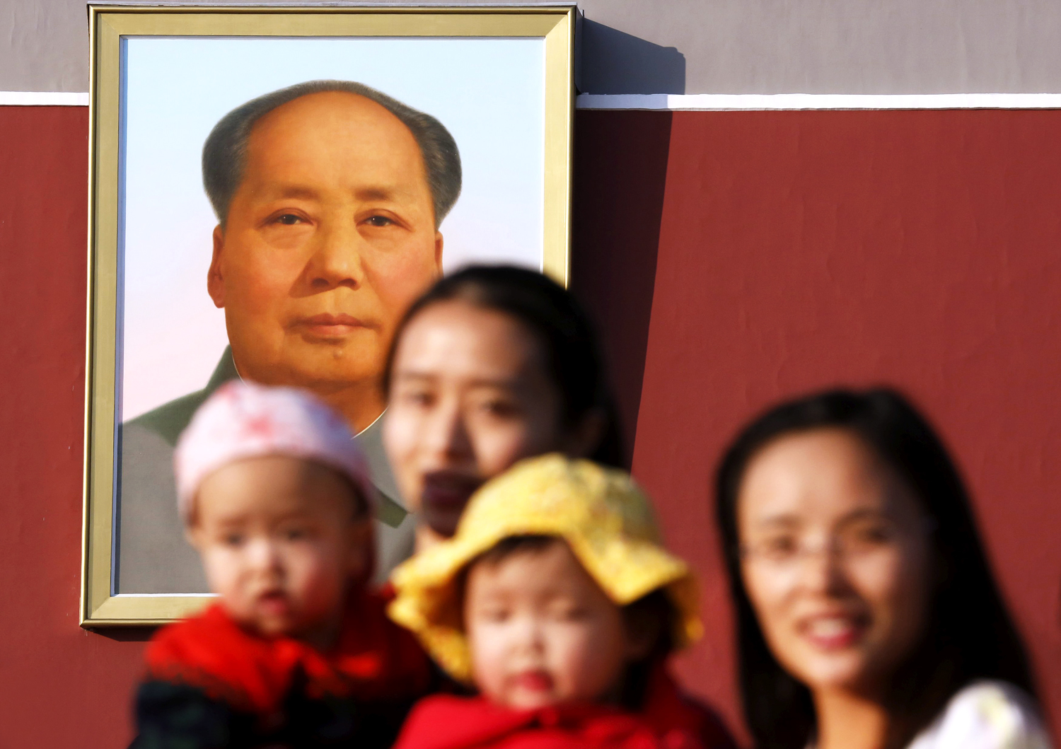 Two women and their babies pose for photographs in front of the giant portrait of late Chinese chairman Mao Zedong at the Tiananmen Gate in Beijing. Photo: Reuters
