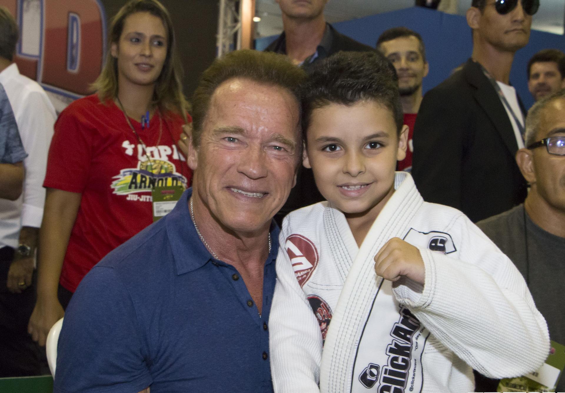 Arnold Schwarzenegger with a budding martial artist at an Arnold Classic event.