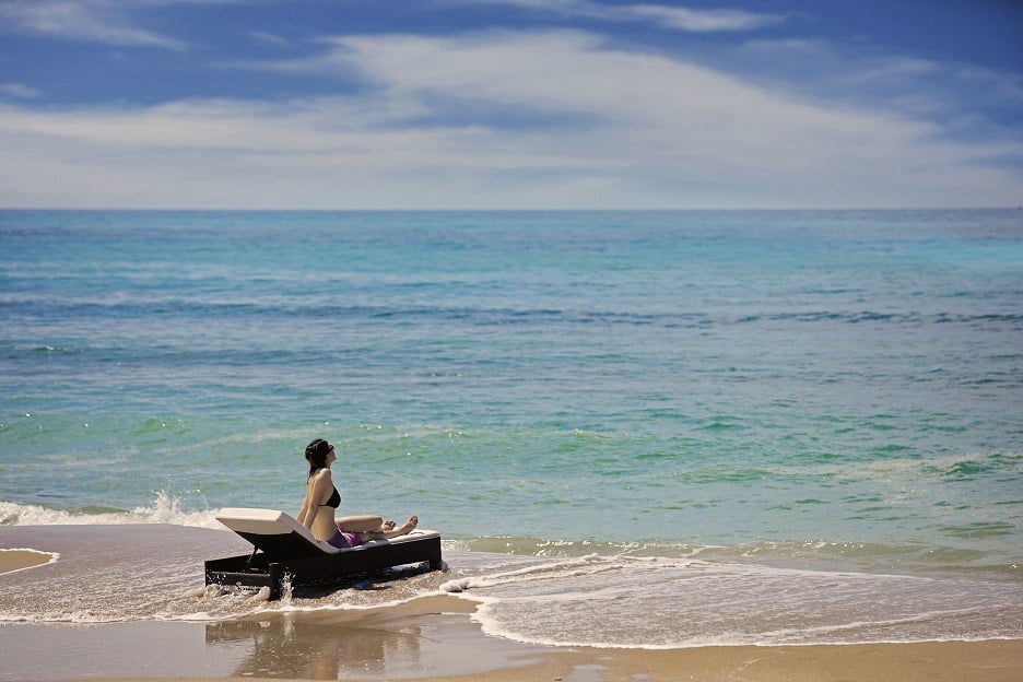 A tourist enjoys the great ocean views in a beach in Sanya.