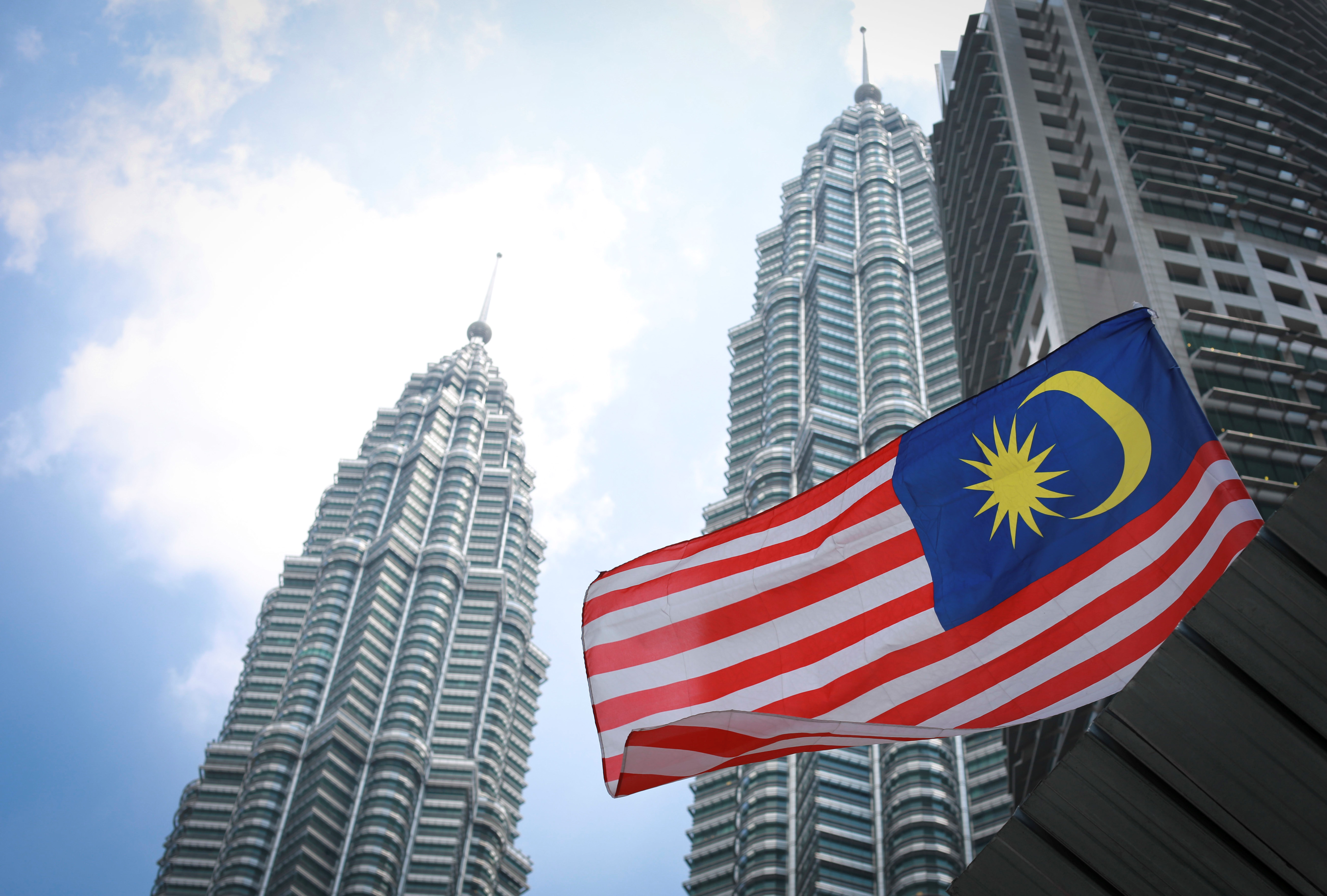 Malaysia's national flag flies in front of its landmark Petronas Twin Towers in Kuala Lumpur, Malaysia. photo: AP Photo/Vincent Thian