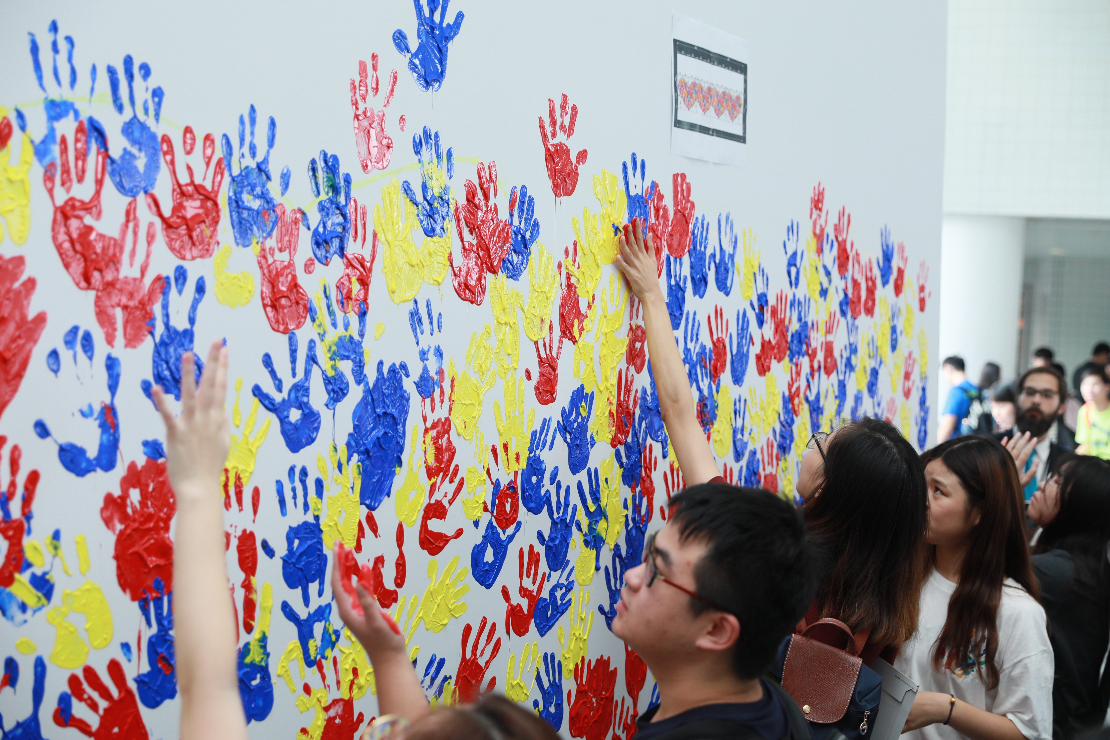 1,661 HKUST members create a huge handprint painting.