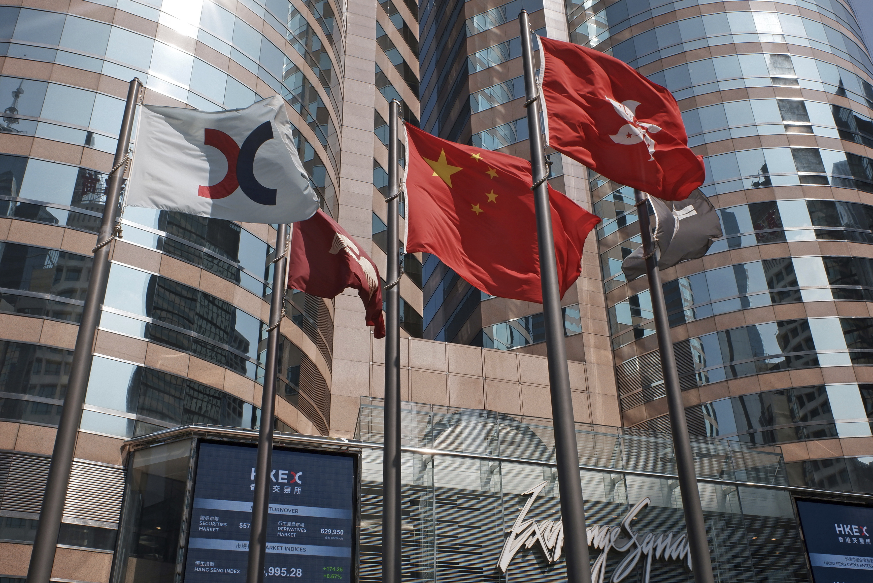 Flags are raised outside the Hong Kong Exchange Square building. Investors are geared up for trading in the Year of the Rat on Wednesday. Photo: AP Photo