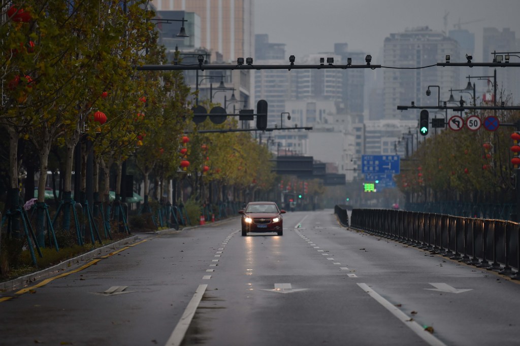 A lone car drives down a disserted street in Wuhan on January 26, 2020. Photo: AFP