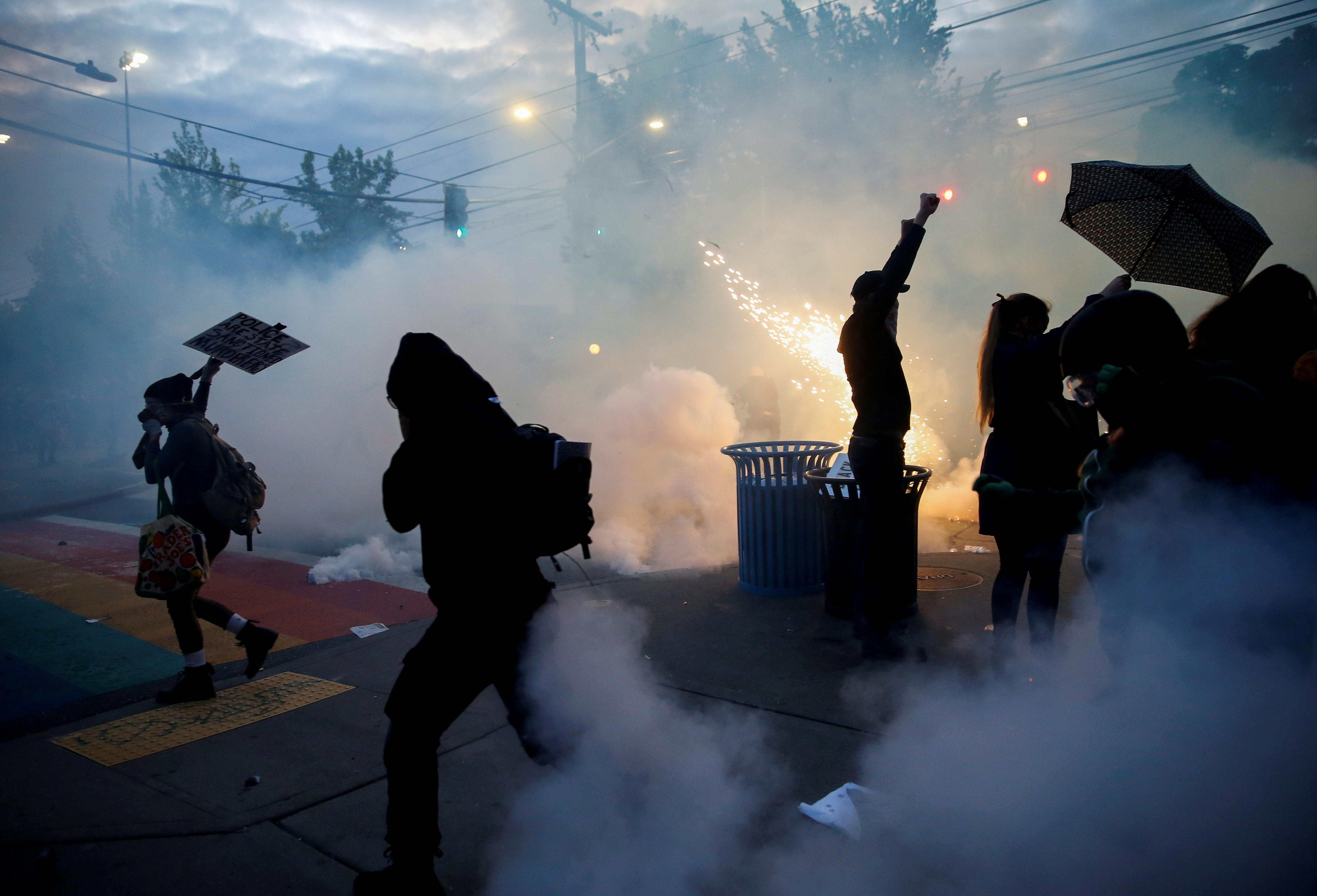 Protesters disperse as tear gas, pepper spray and flash-bang devices are deployed by Seattle police during a protest against police brutality and the death in Minneapolis police custody of George Floyd, in Seattle, Washington. 
