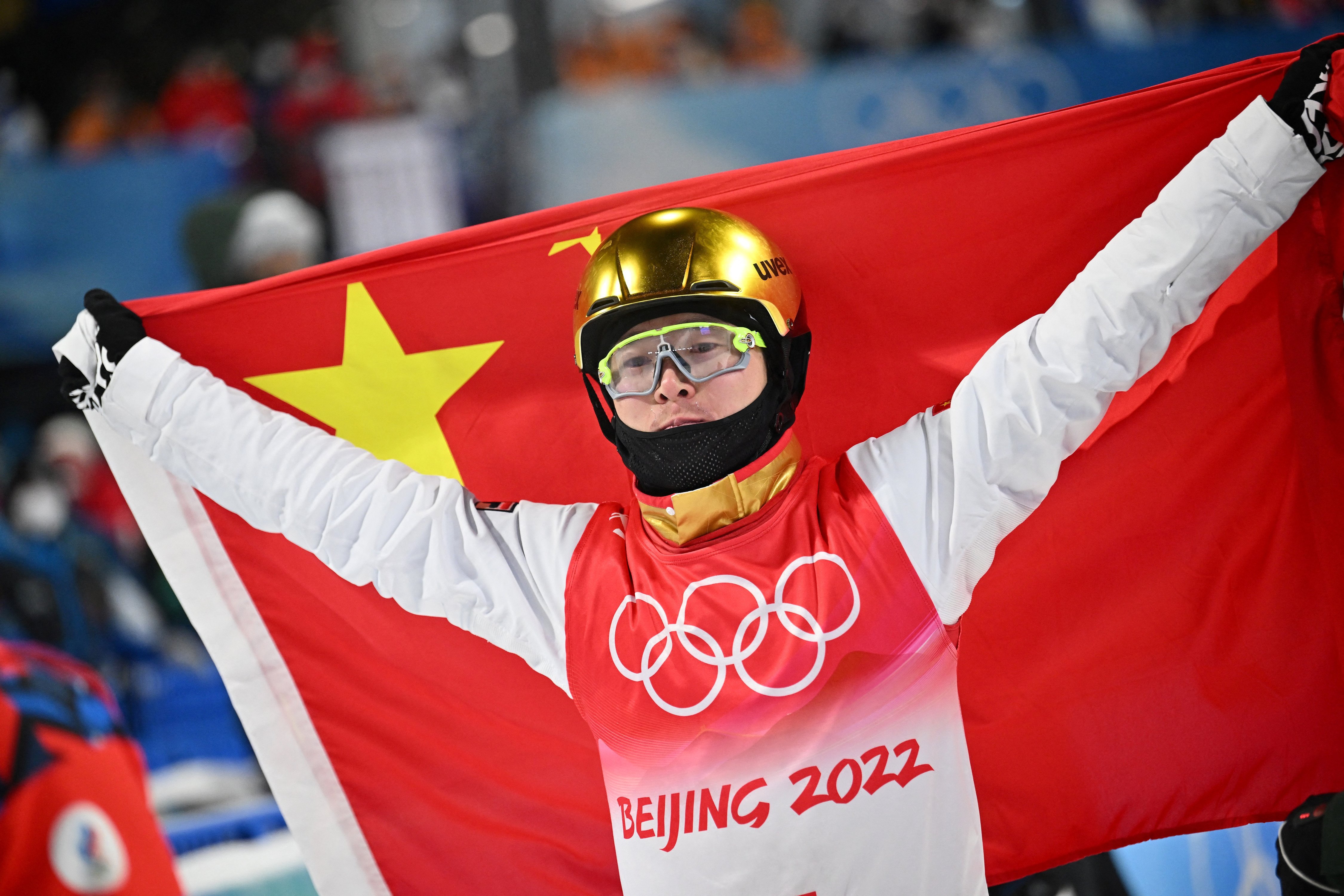 China’s Qi Guangpu holds his national flag after winning the freestyle skiing men’s aerials final. Photo: AFP
