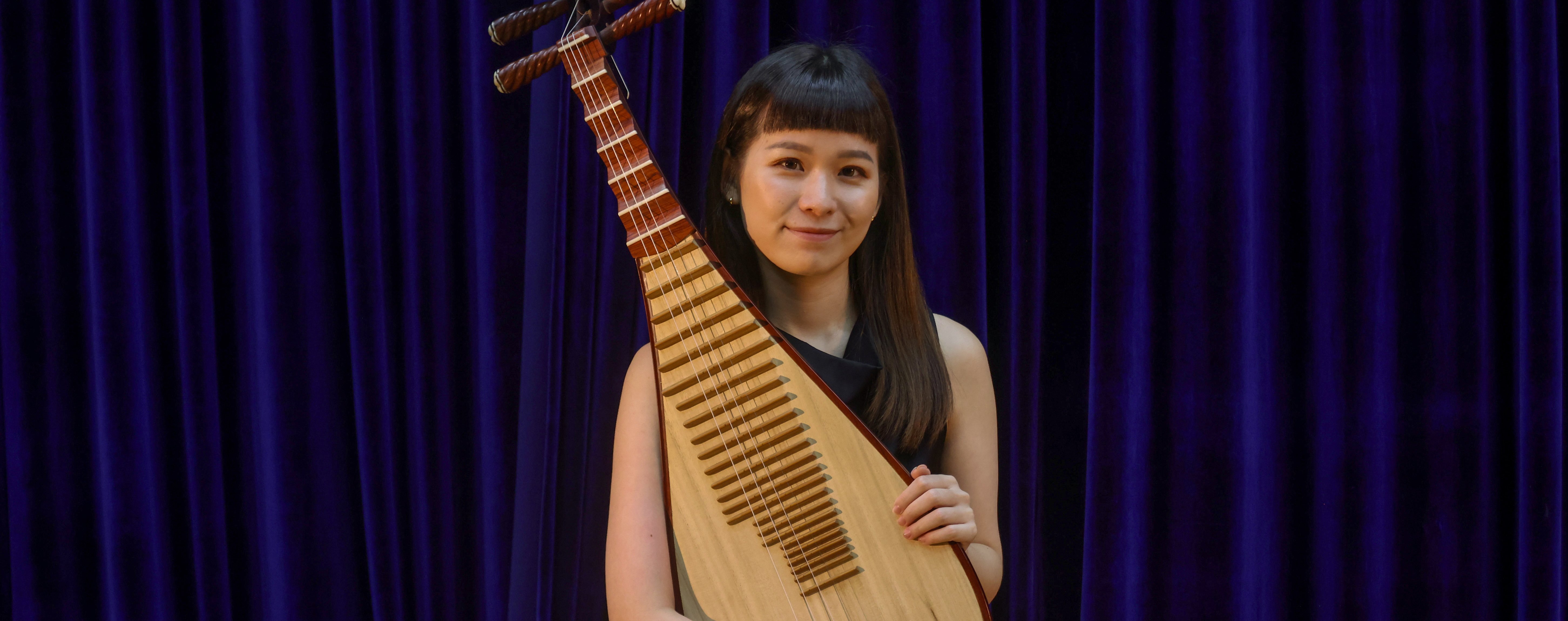 Hong Kong Chinese Orchestra member Wang Kaihan sits with her pipa. Photo: Jonathan Wong