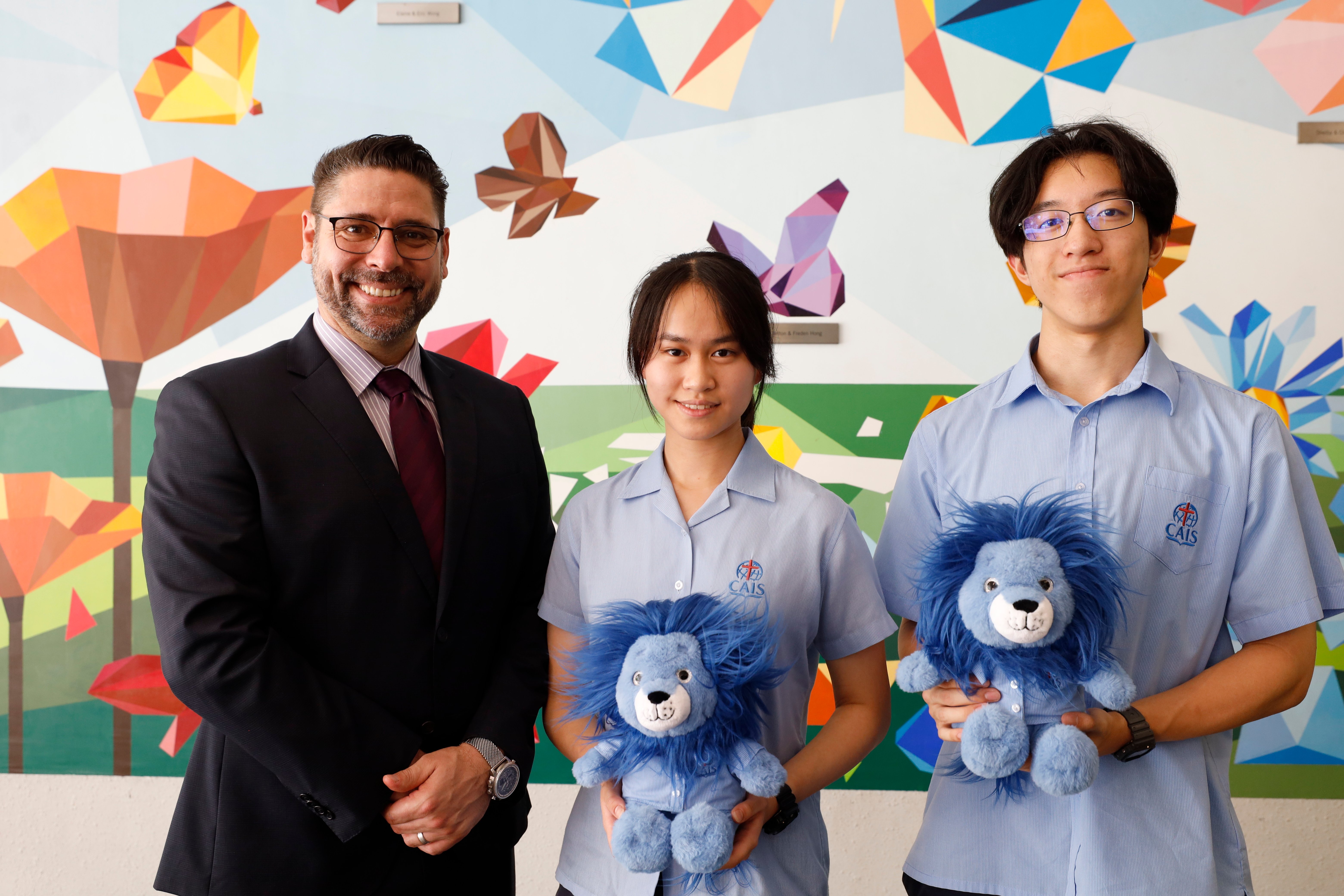 CAIS Acting Head of School, Daniel Schick, congratulates students, Tinkie Chan and Ian Ma, on achieving full scores on the IB
