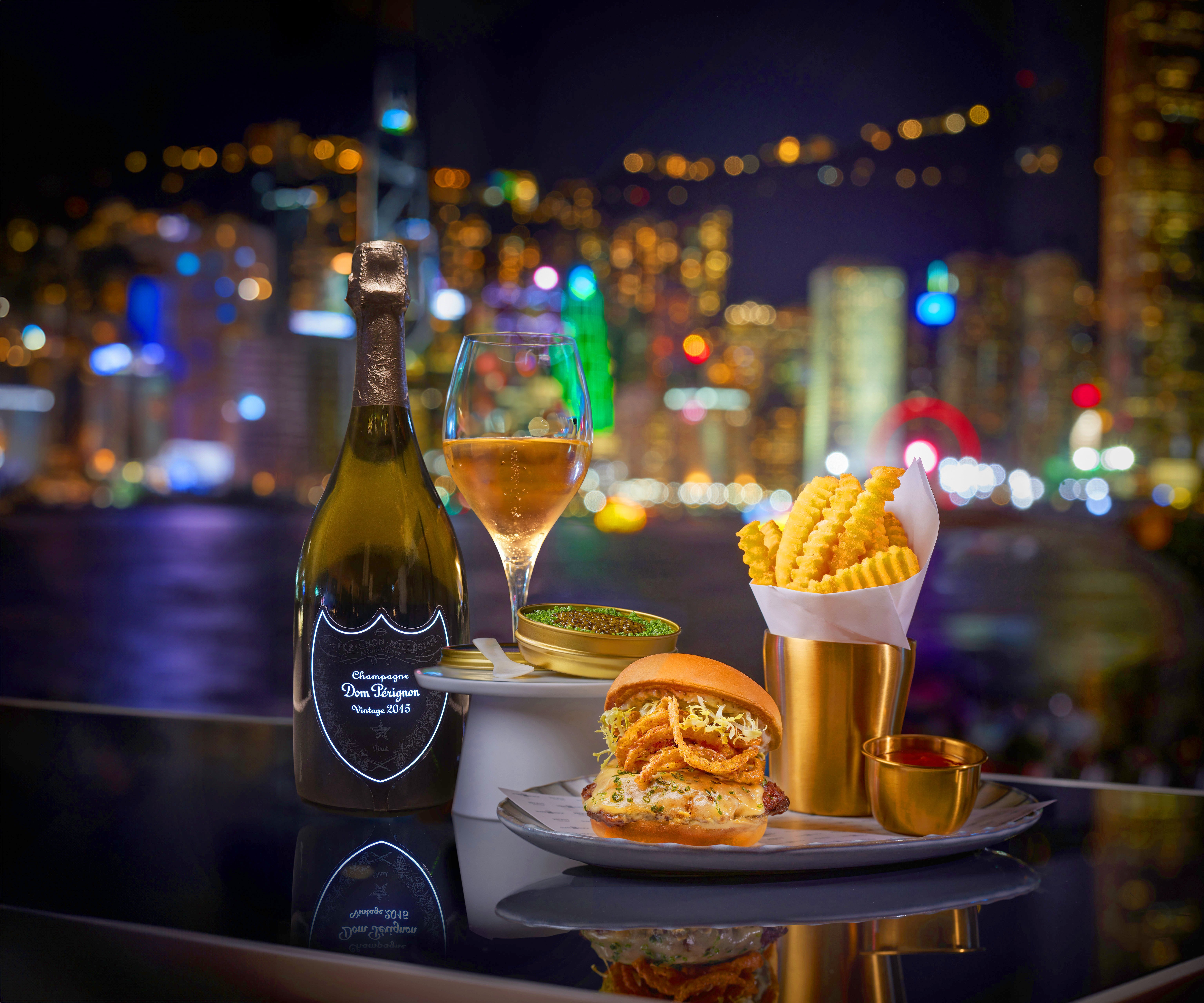 A gourmet burger dressed for the evening with caviar fries and a glass of Dom Pérignon