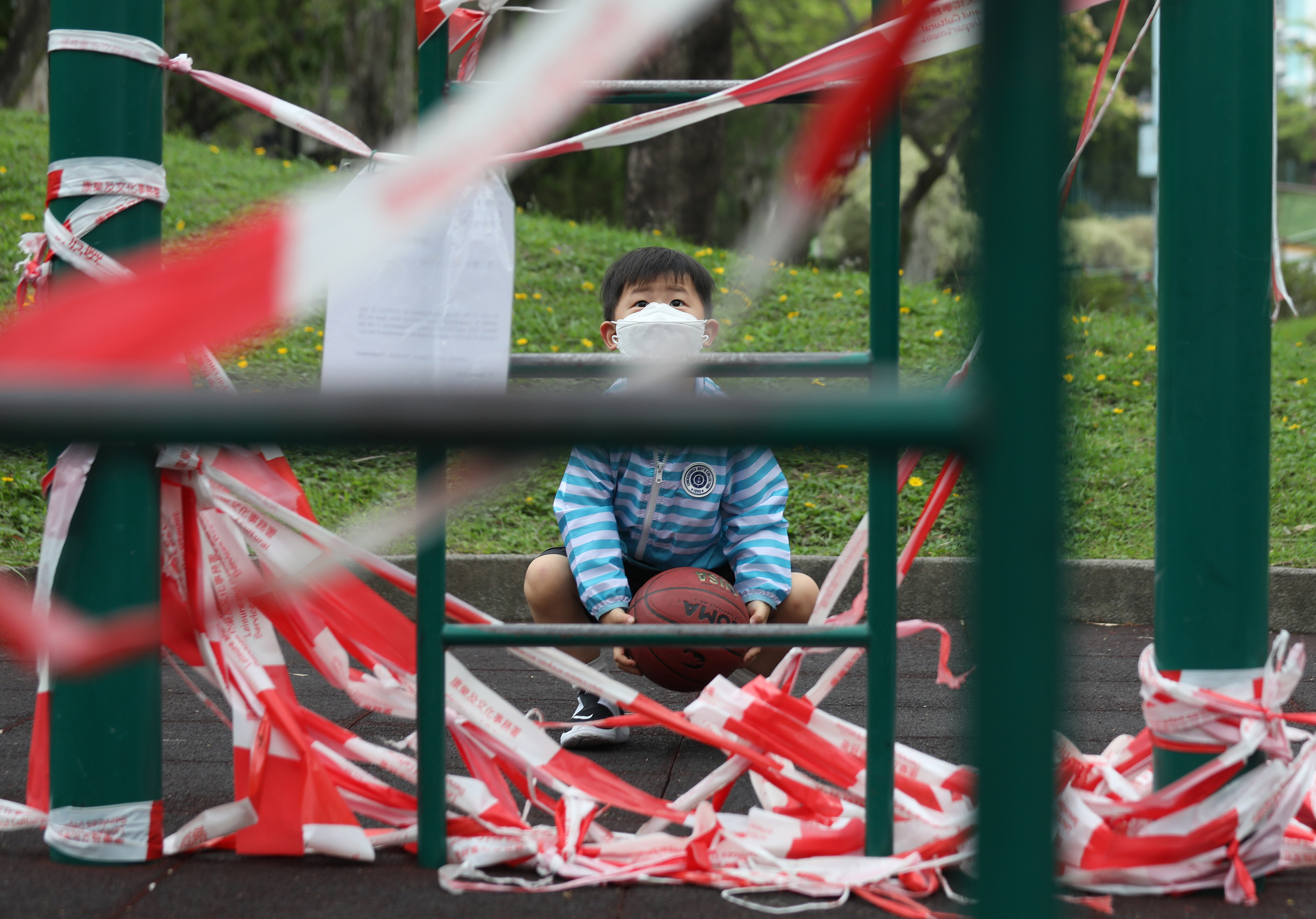 A boy looks wistfully at a cordoned-off playground in Kowloon City on April 25, 2020. Public playgrounds have been a casualty of the government’s coronavirus prevention measures. Photo: Xiaomei Chen