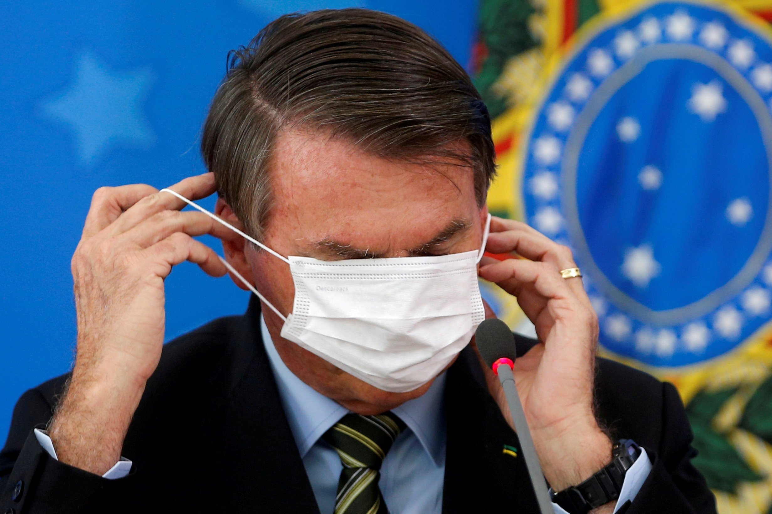 Brazilian President Jair Bolsonaro adjusts his face mask during a news conference in Brasilia, Brazil, on March 18, 2020. Under Biden, Bolsonaro’s far-right discourse is likely to fall on deaf ears. Photo: Reuters