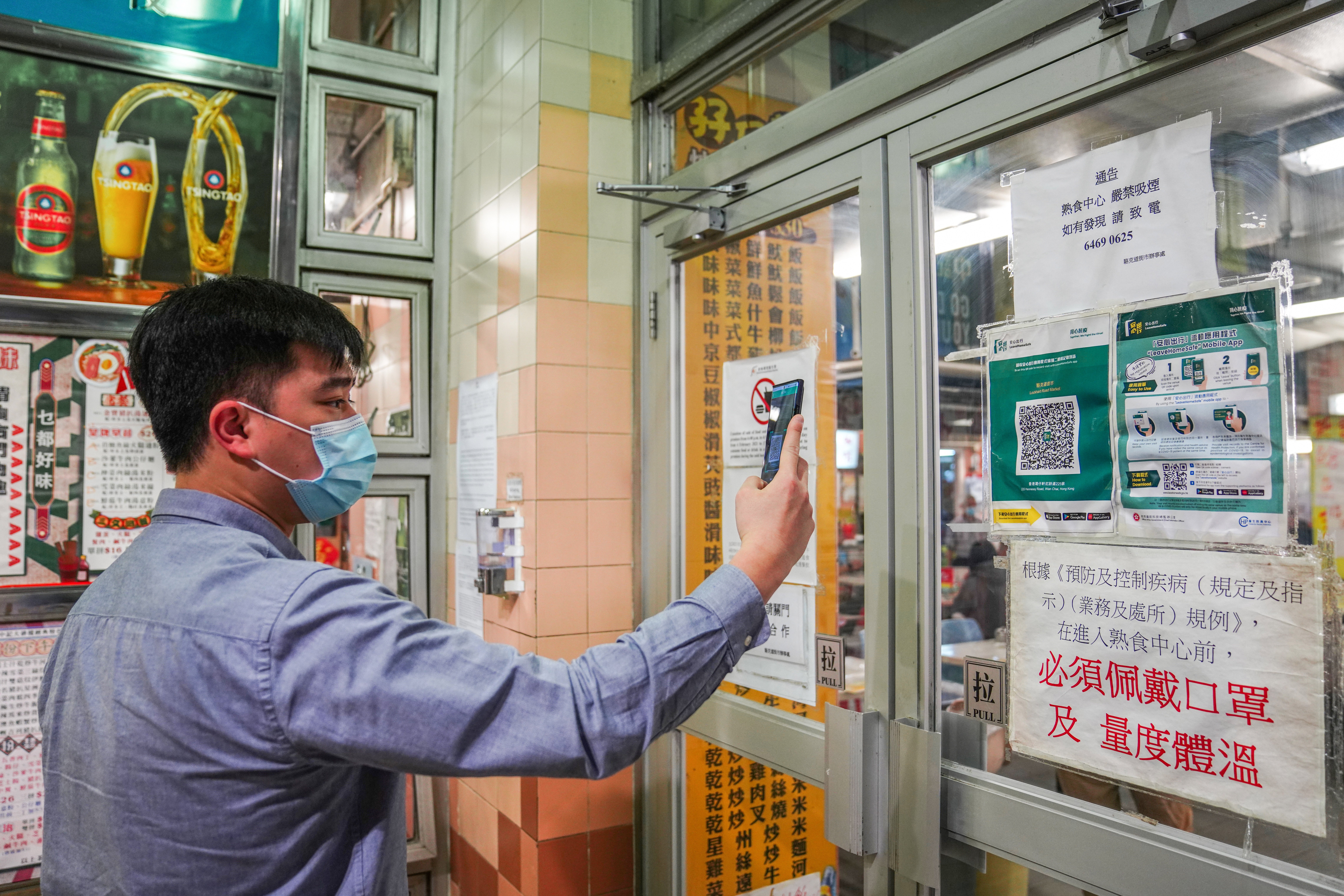A man scans a QR code via the “Leave Home Safe” app to enter a restaurant in Wan Chai on February 18. Photo: Sam Tsang