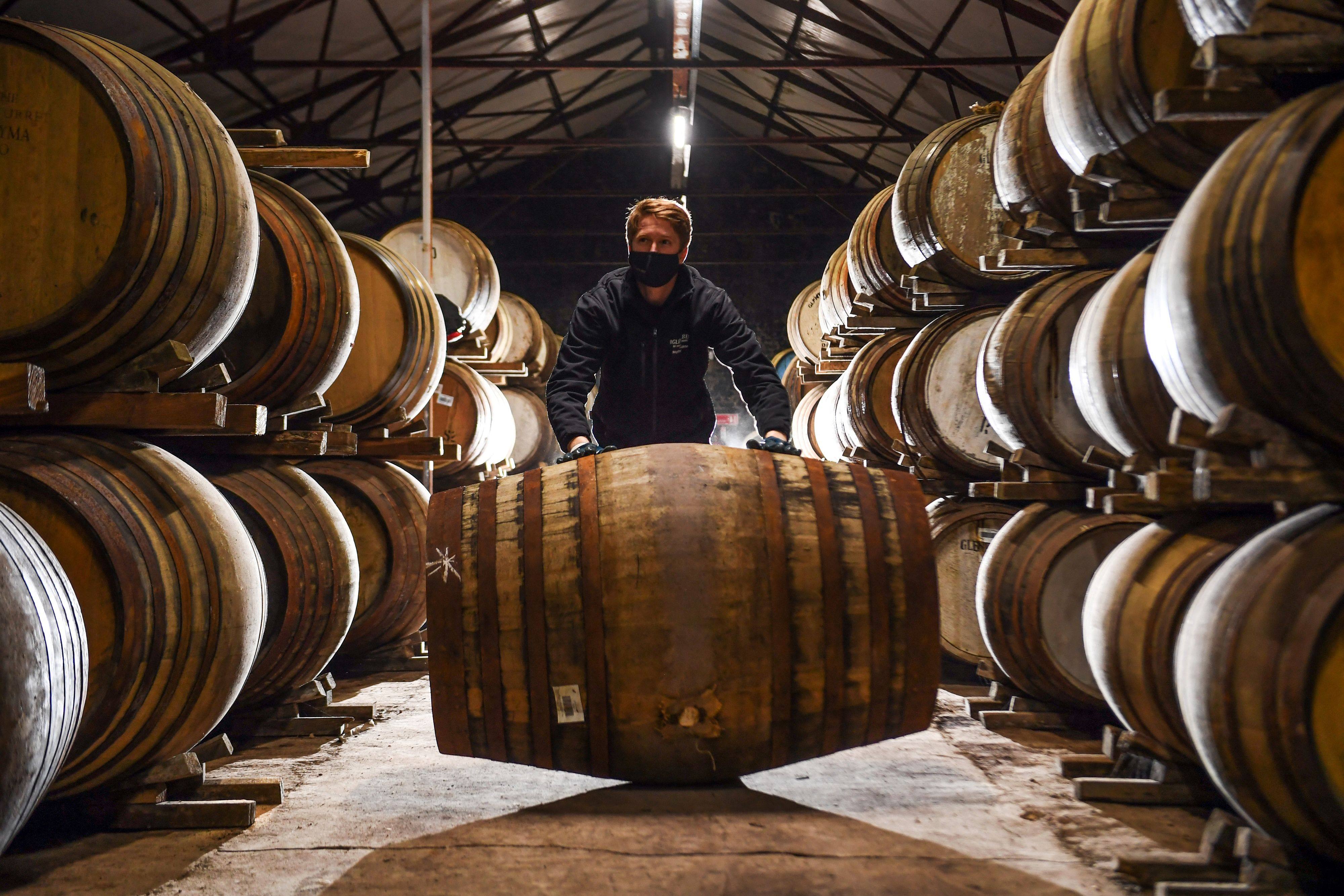 Employee Matthew Coulson rolls a whisky cask in the Glenturret Distillery’s bonded warehouse in Crieff, Scotland. It has been a tough period for Scotland’s oldest whisky maker. Photo: AFP