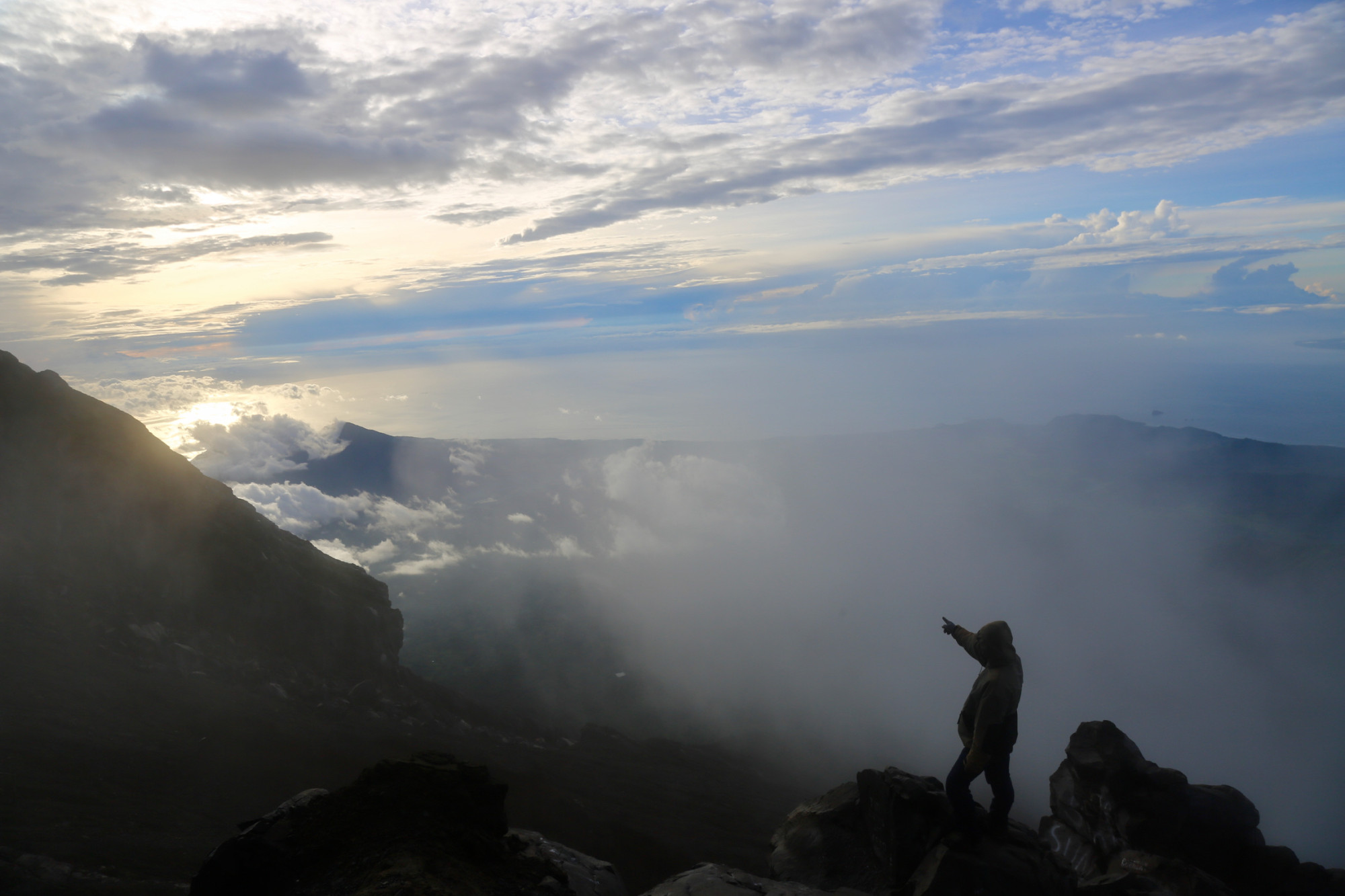 The sun peaks out over the neighbouring island of Lombok, as seen from Mount Agung. Photo: Ian Neubauer