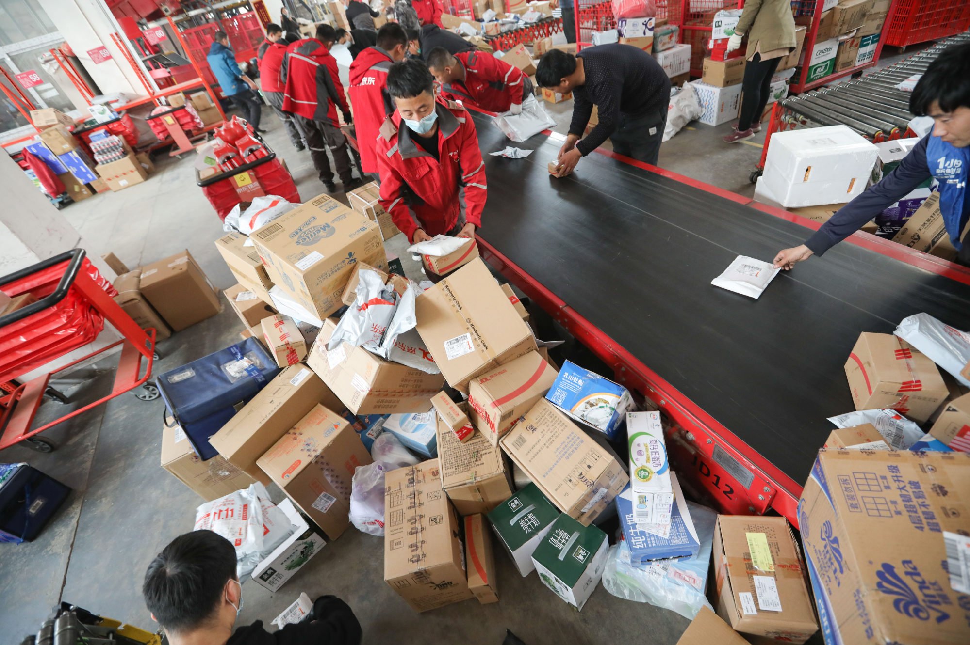 Workers sort out packages for delivery at a JD.com delivery station in Beijing, China, on November 11, 2020. Photo: Simon Song