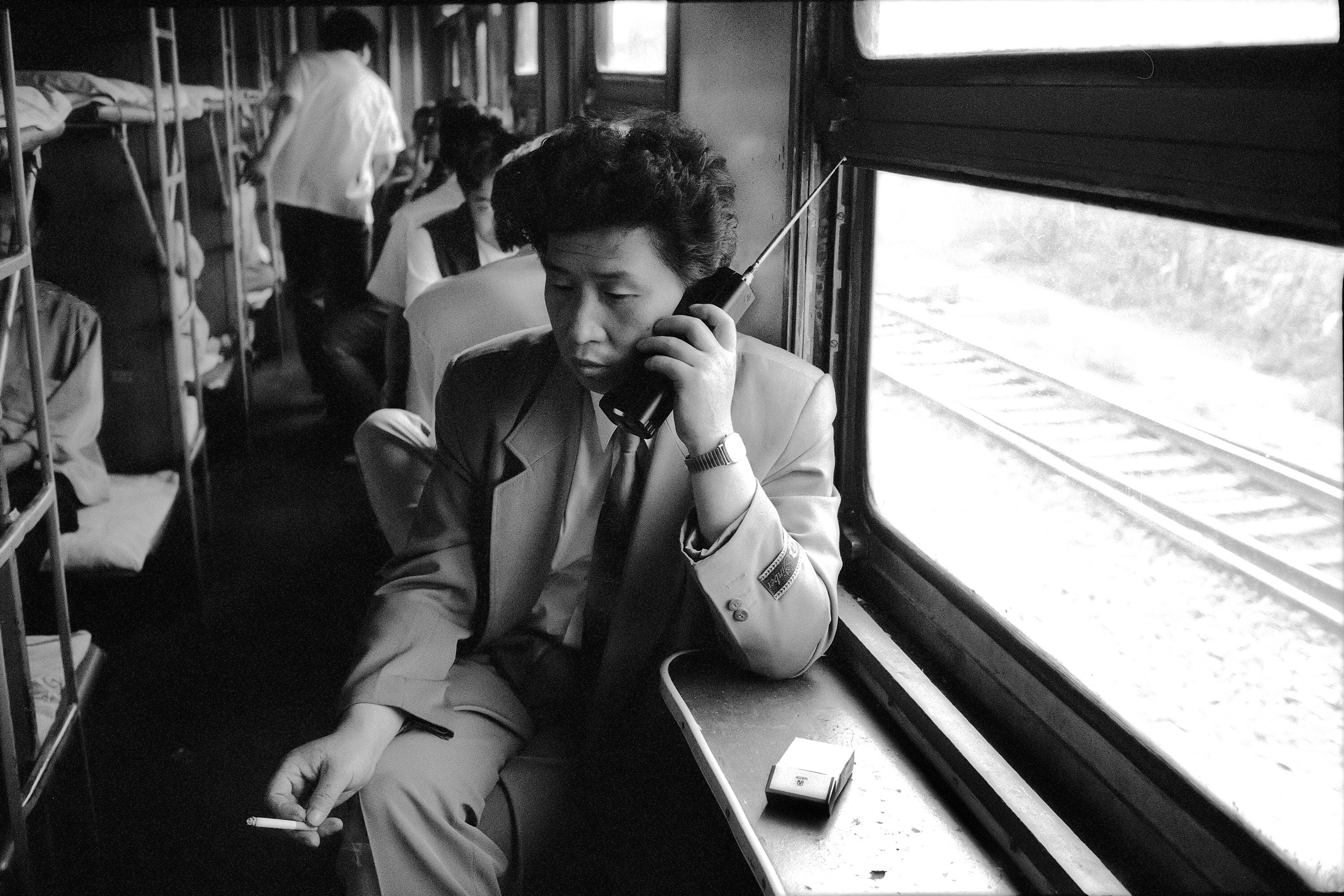 A man on an old mobile phone on the Shenyang–Dalian railway line in China, 1994. Photo: Wang Fuchun