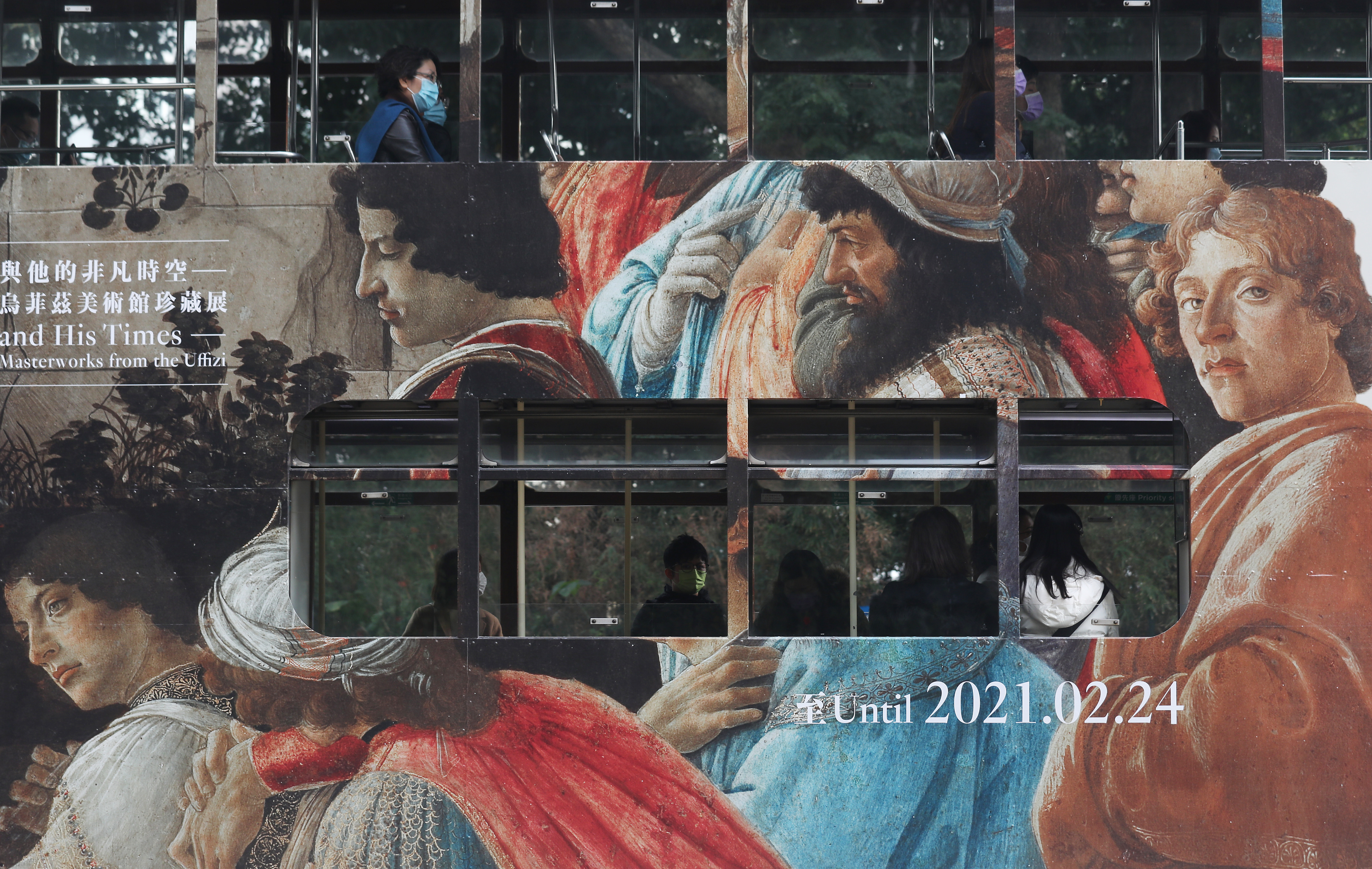 People travel on a tram covered in an ad for the “Botticelli and His Times” exhibition at the Hong Kong Museum of Art in December 2020. Photo: Xiaomei Chen