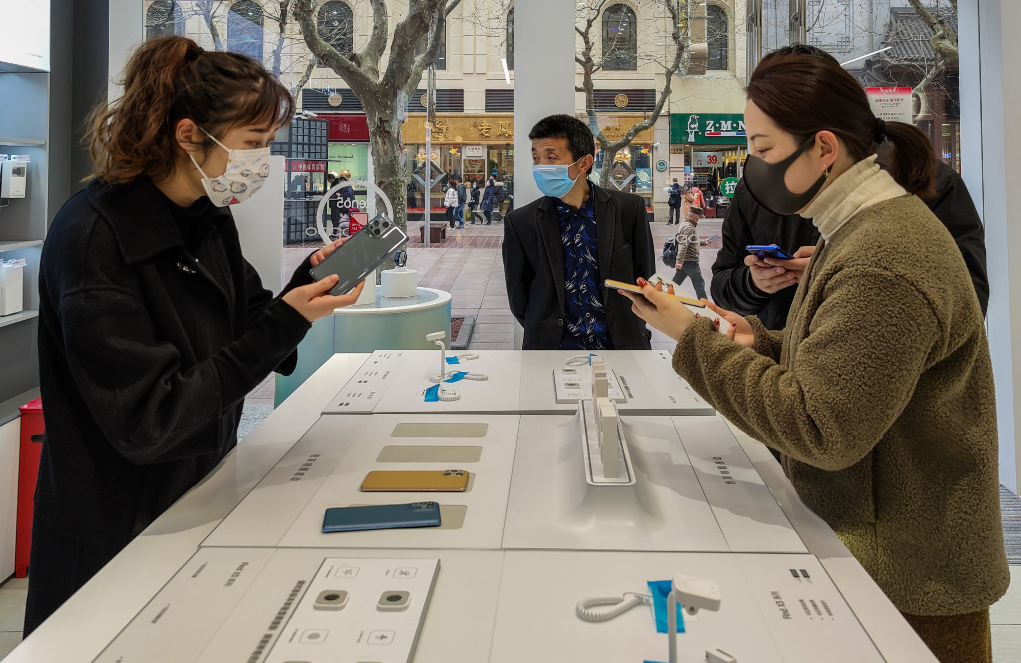 Customers try out Oppo Find X3 smartphones in Shanghai. Photo: Getty Images
