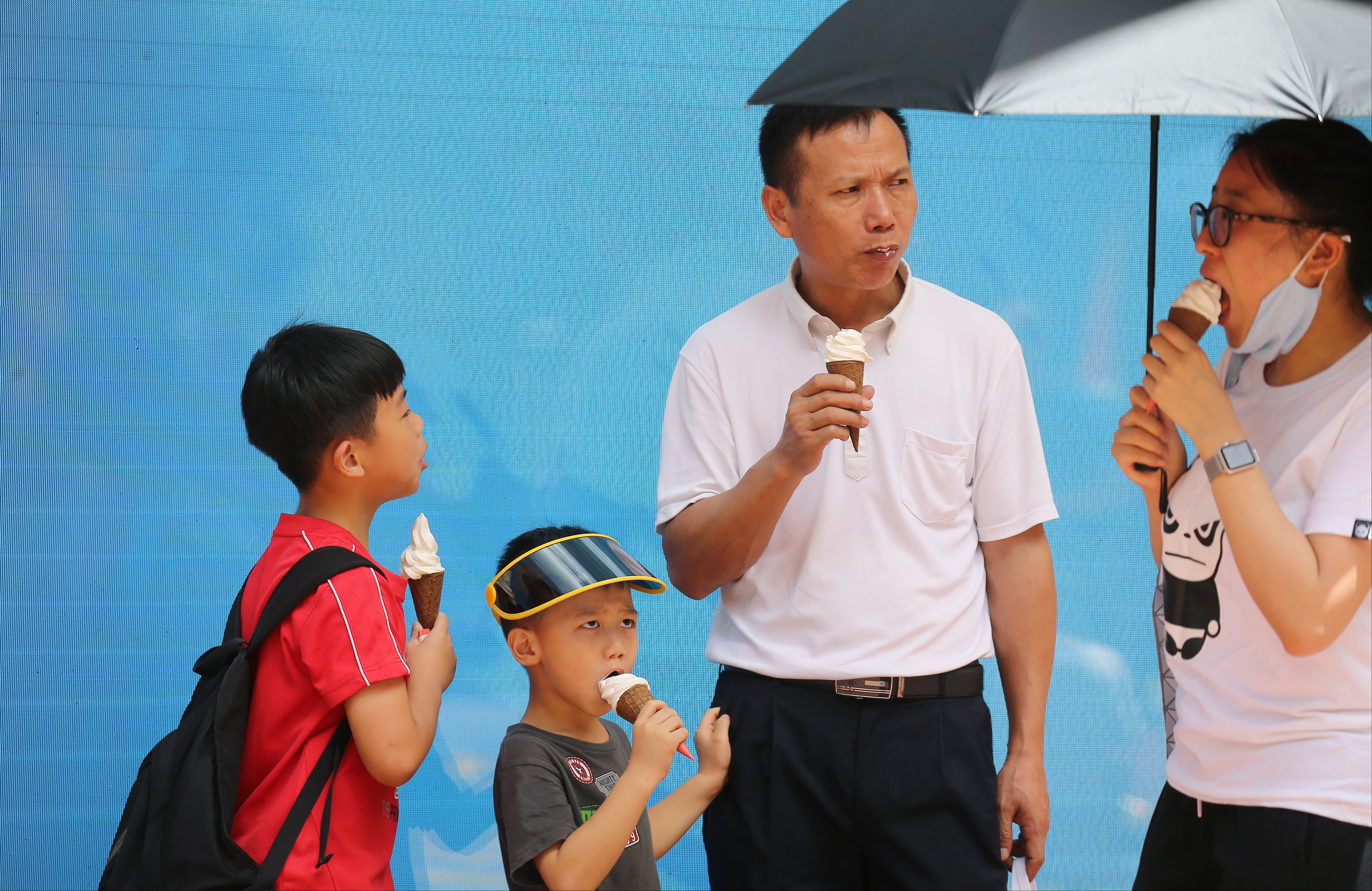 A family photographed eating ice cream in Causeway Bay. The Hong Kong Observatory issued the Very Hot Weather Warning this morning. 01AUG18 SCMP / Dickson Lee
