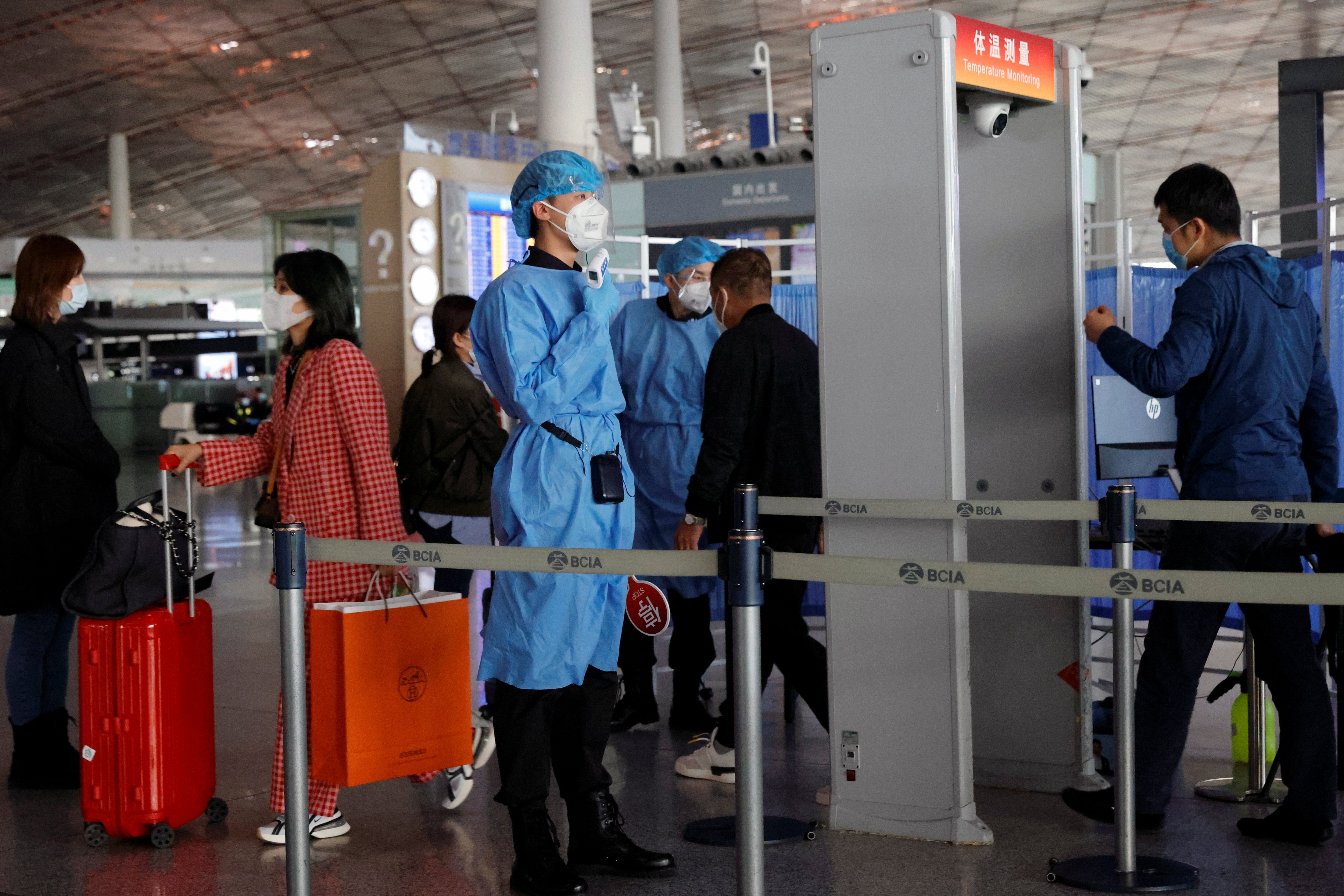 Medical staff check people’s temperature as they enter Beijing’s international airport on November 5, 2020. Photo: Reuters