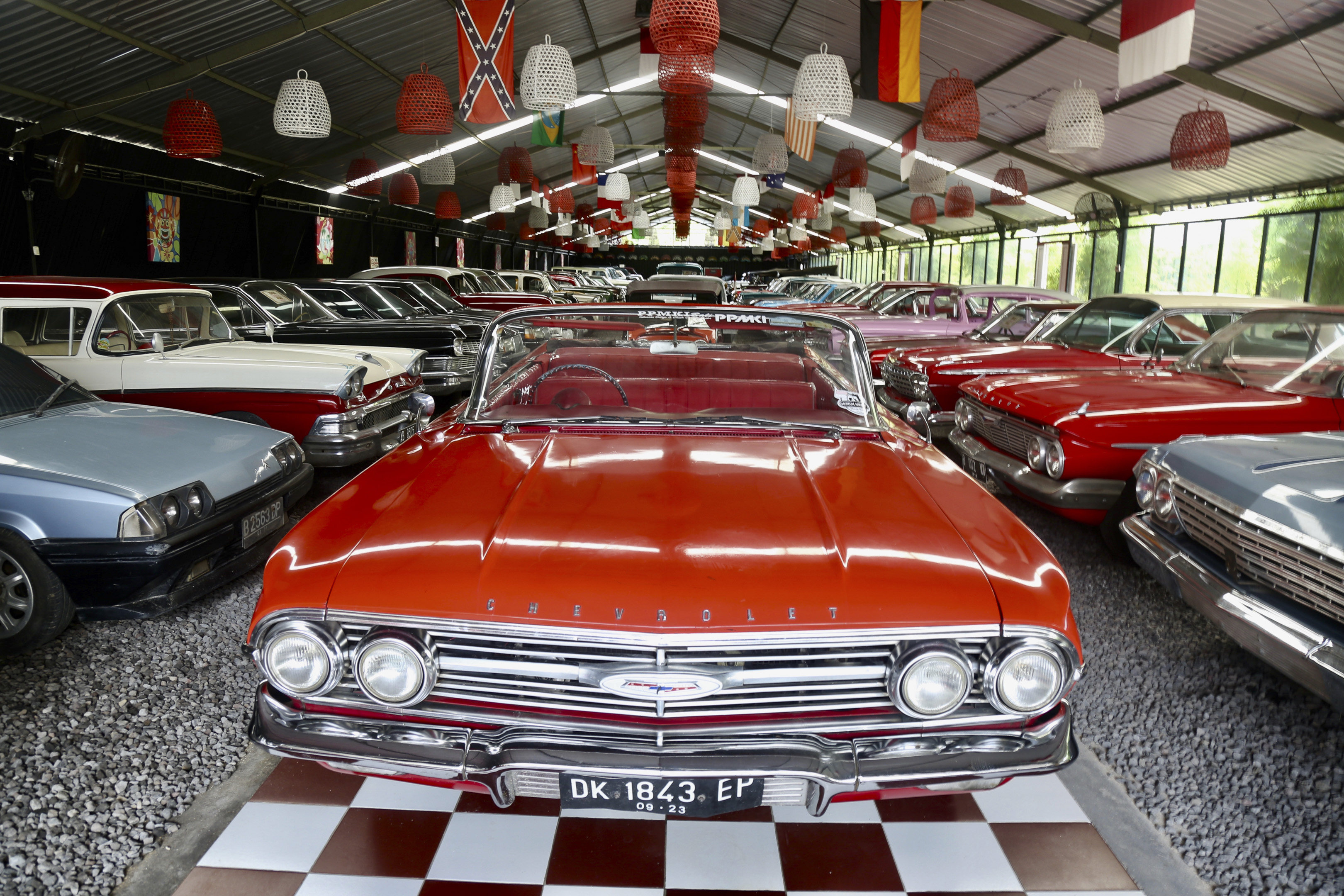 A fire-engine red Chevy Impala 60 cabriolet sits as a centrepiece in one of the airport-size hangars at Kebon Vintage Cars in Bali. Photo: Ian Neubauer