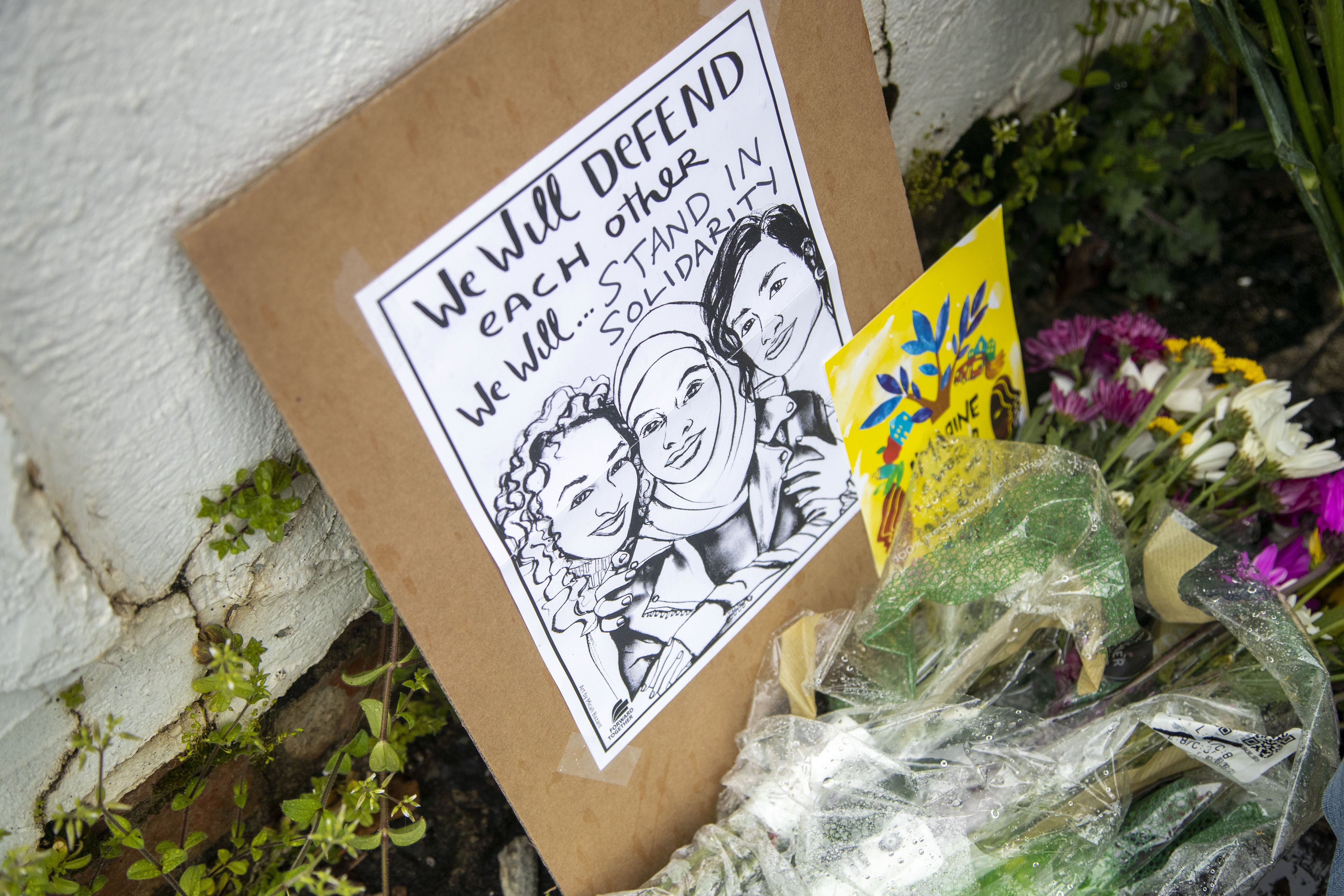 Flowers, candles and signs are displayed on March 17 at a makeshift memorial outside Gold Spa following a mass shooting in Atlanta. Photo: Atlanta Journal-Constitution via AP