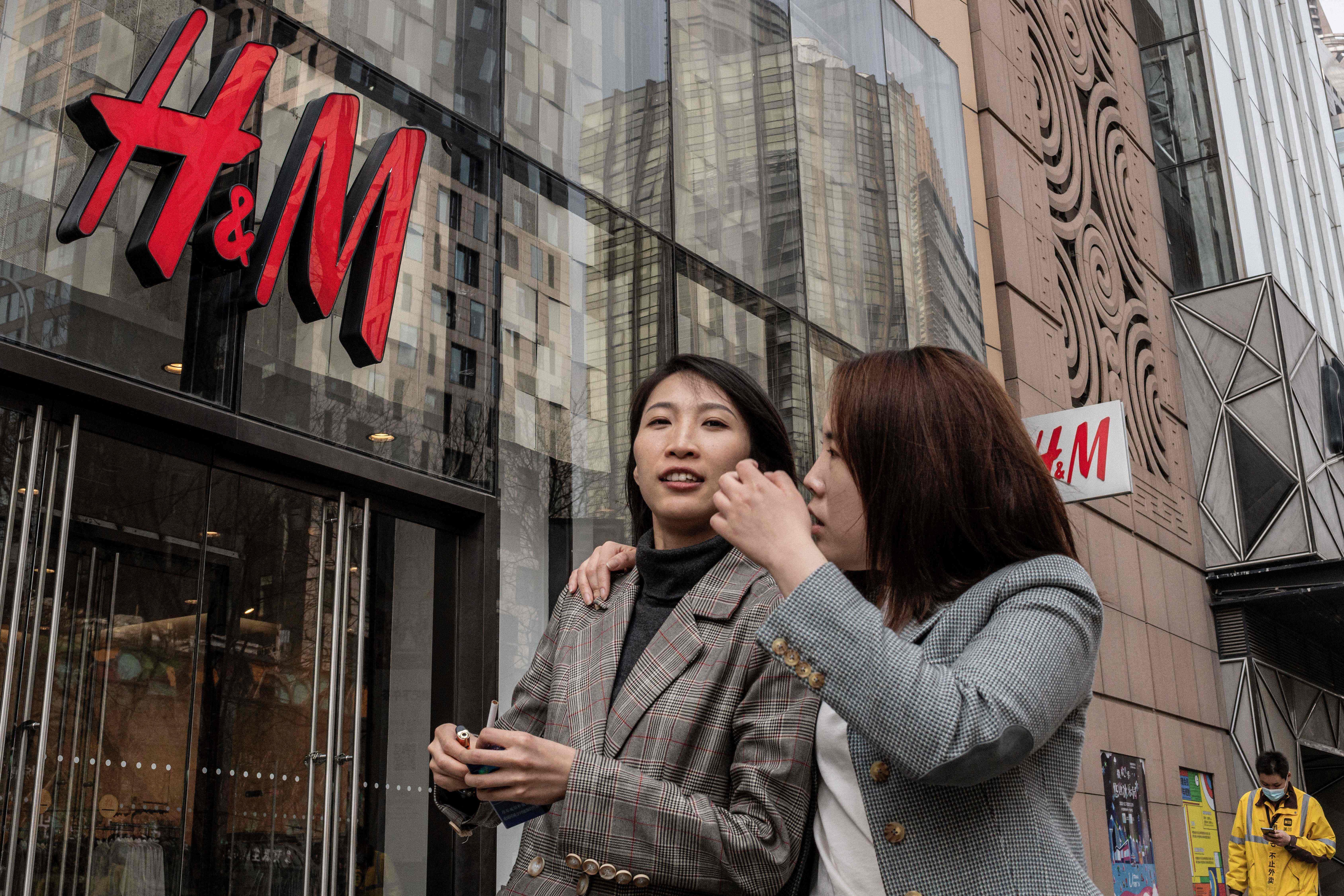 People walk past an H&M store in Beijing on March 25. Photo: AFP
