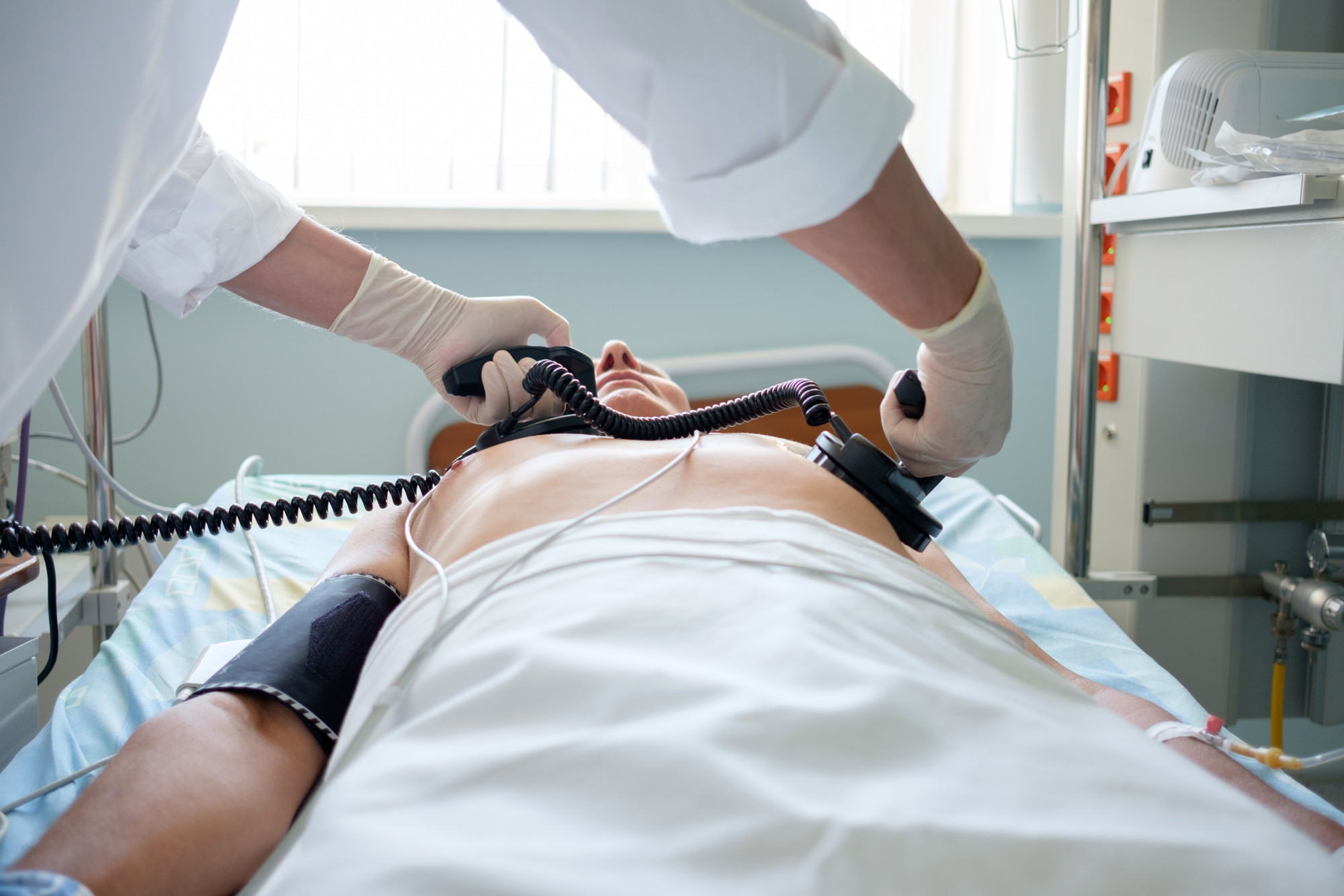A doctor applies a defibrillator to a patient’s chest. Photo: Shutterstock