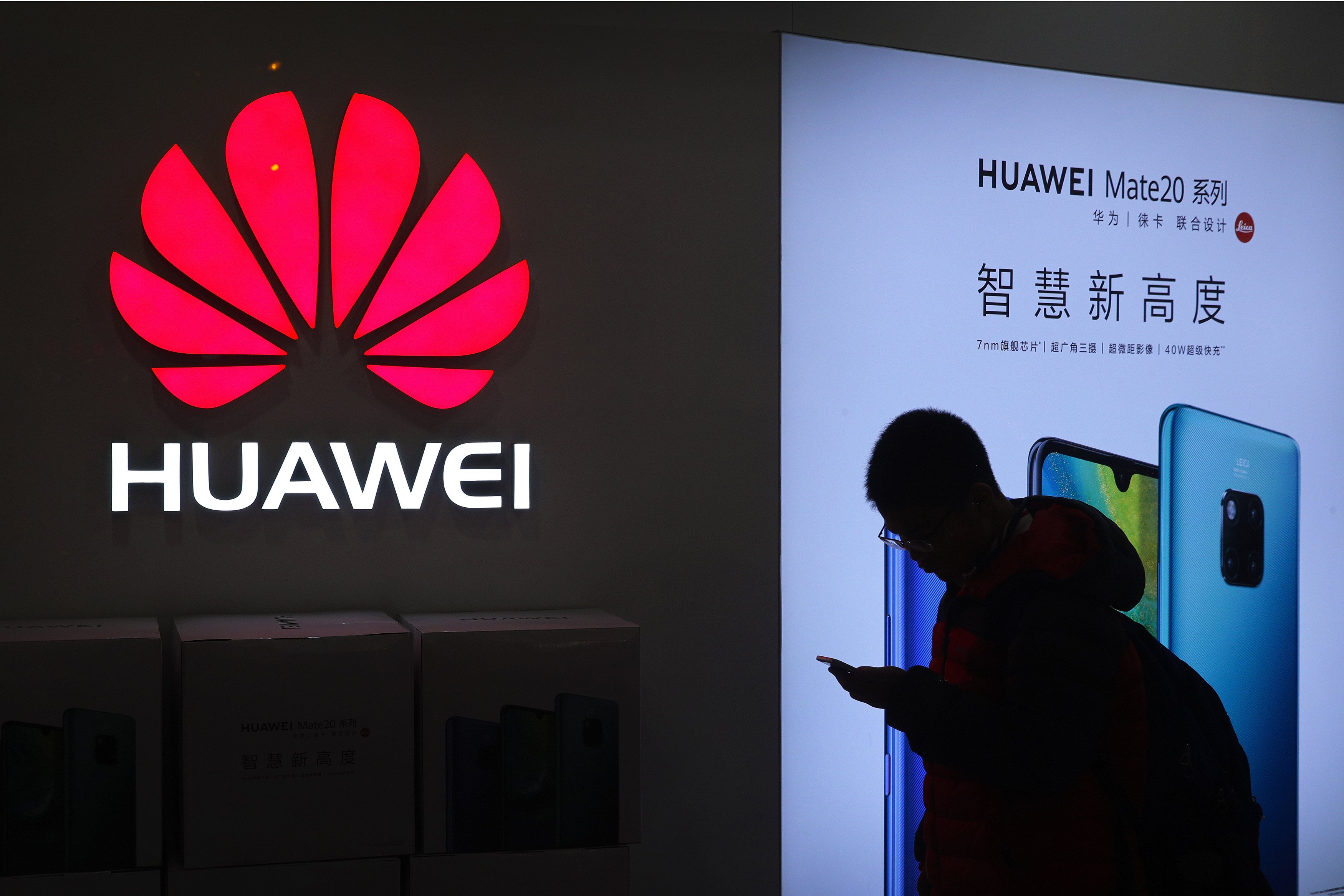 A man browses his smartphone outside a Huawei store at a shopping mall in Beijing. Photo: AP