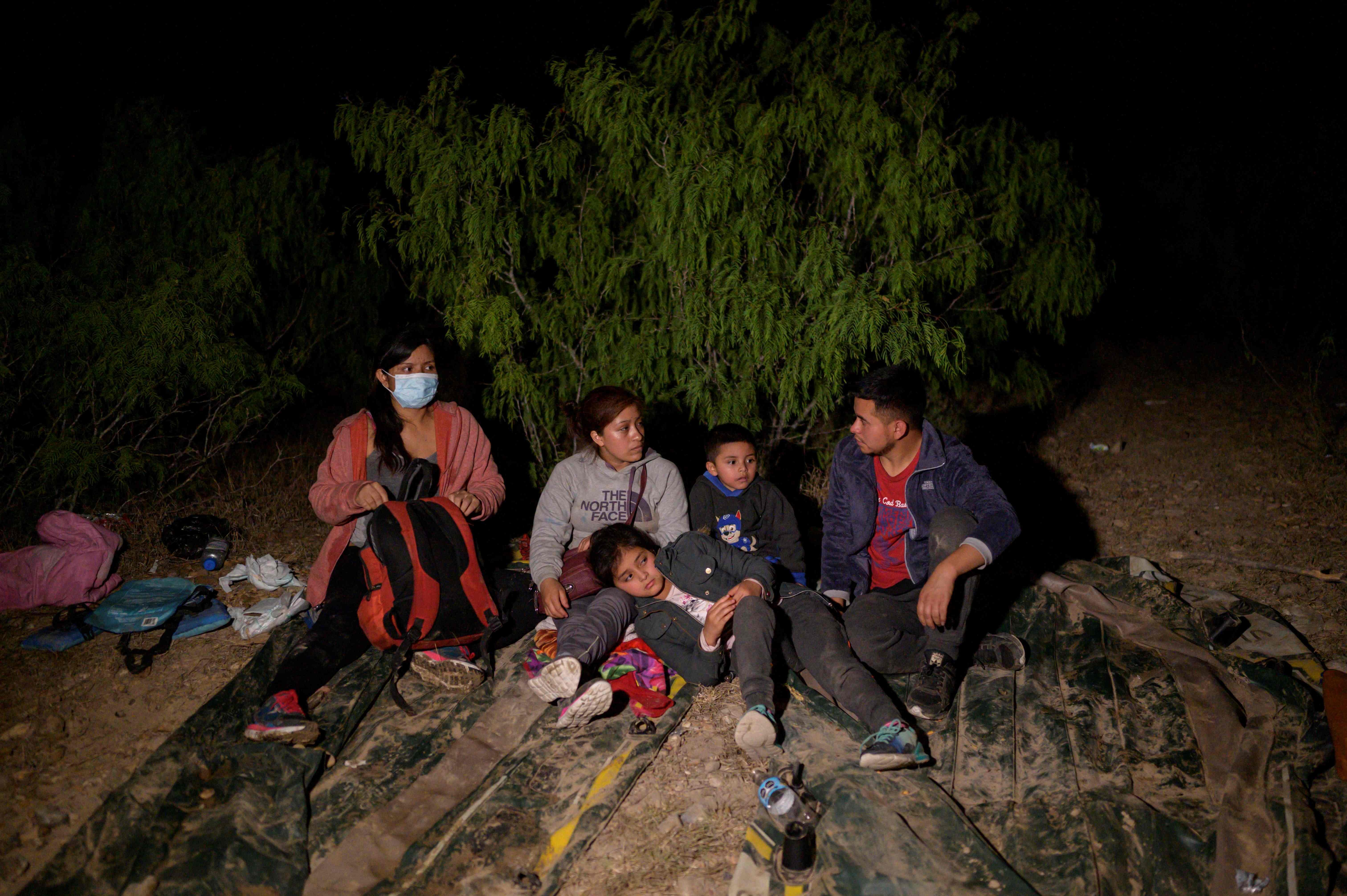 Immigrants from Guatemala, who arrived illegally across the Rio Grande river from Mexico, rest on the US side of the river bank. Photo: AFP