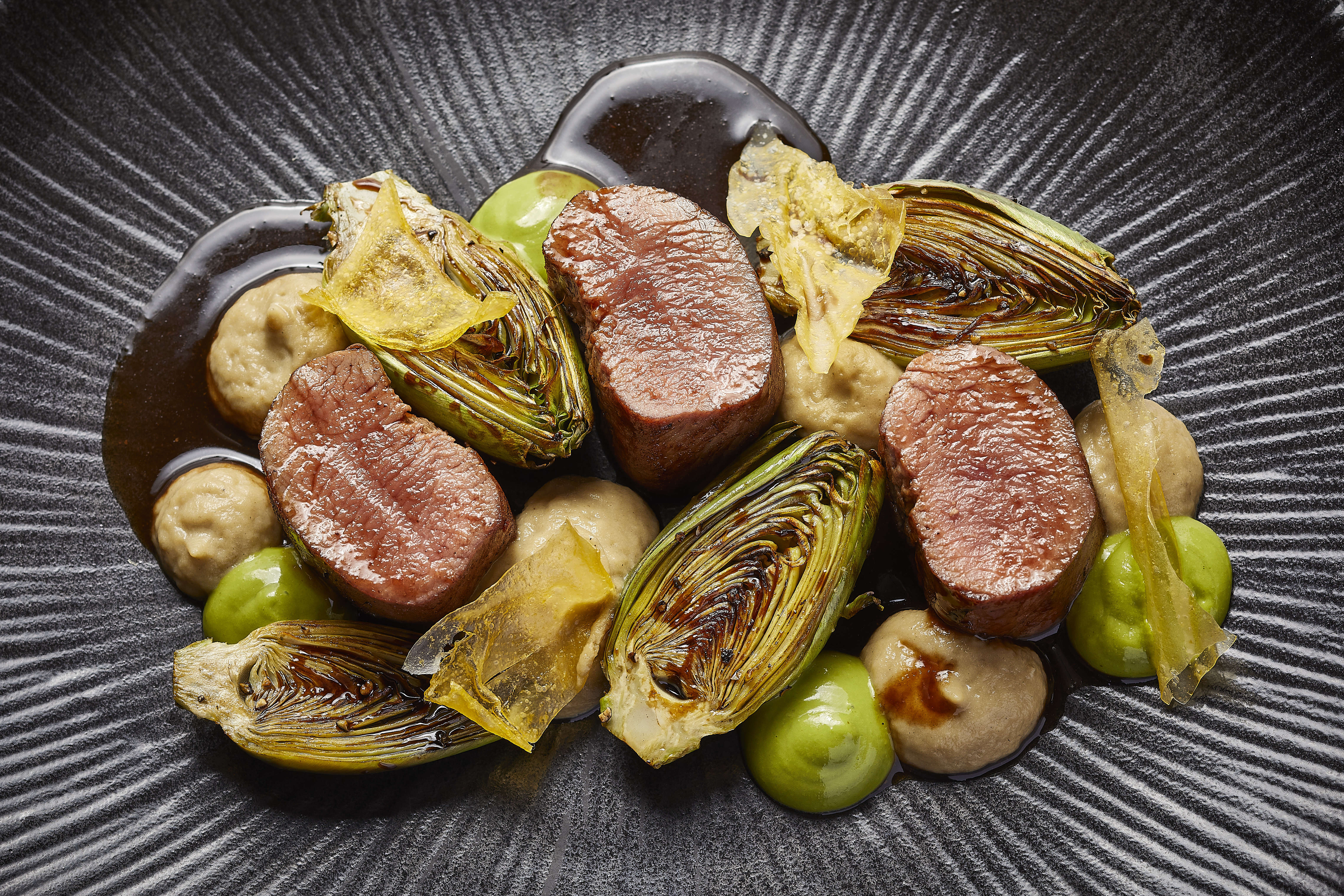 Slow-cooked New Zealand lamb loin with smoked aubergine purée, roasted artichokes and mint salsa verde. Photo: Spiga